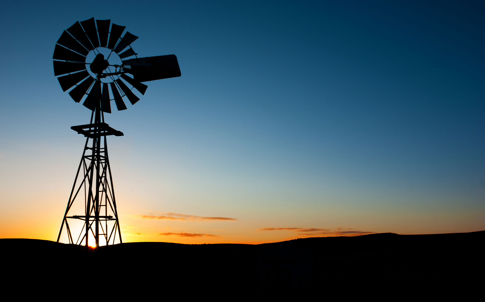 bigstock-Sun-rises-behind-a-windmill-15656000.jpg
