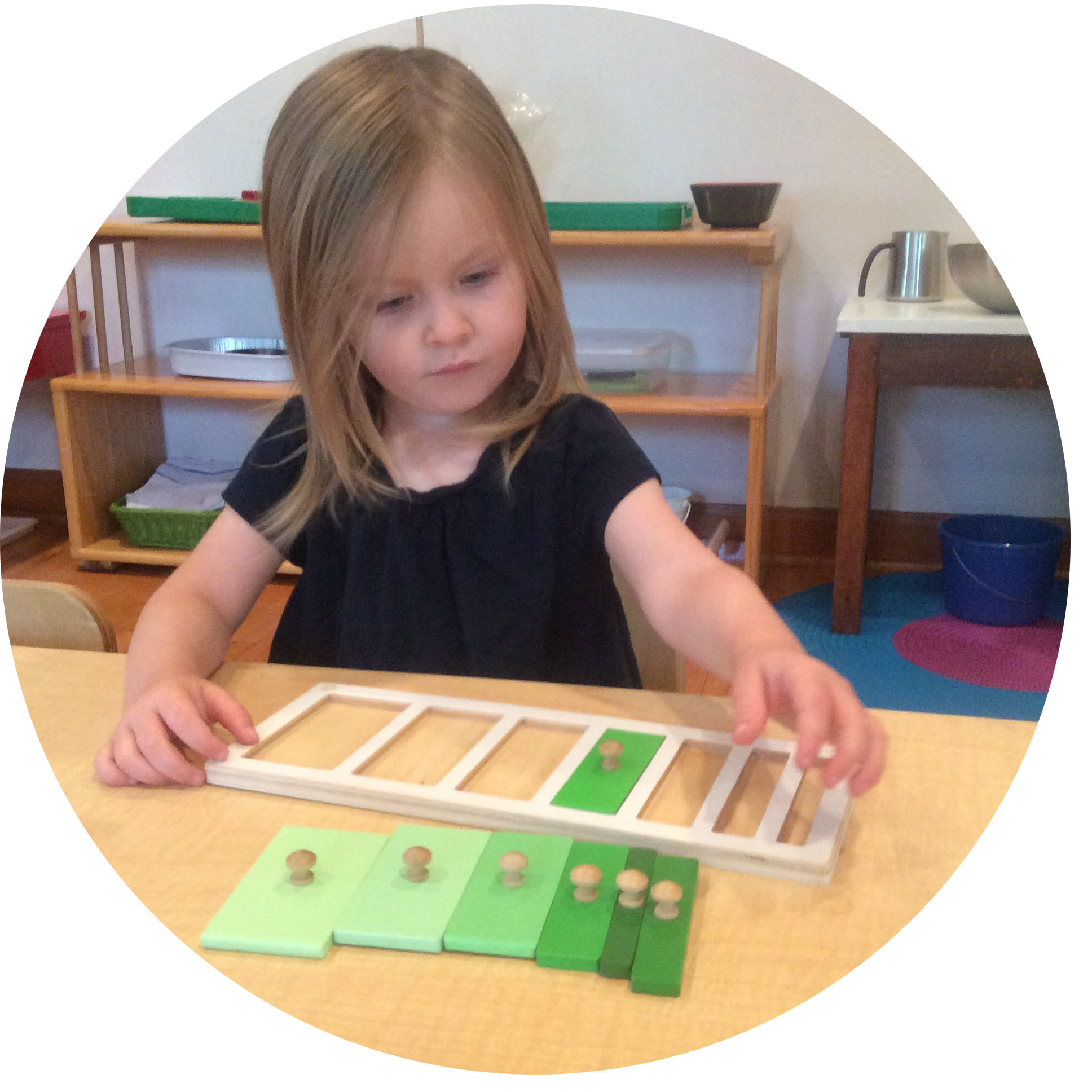 This young toddler is concentrating on a work that introduces concepts of shape, color, and size.