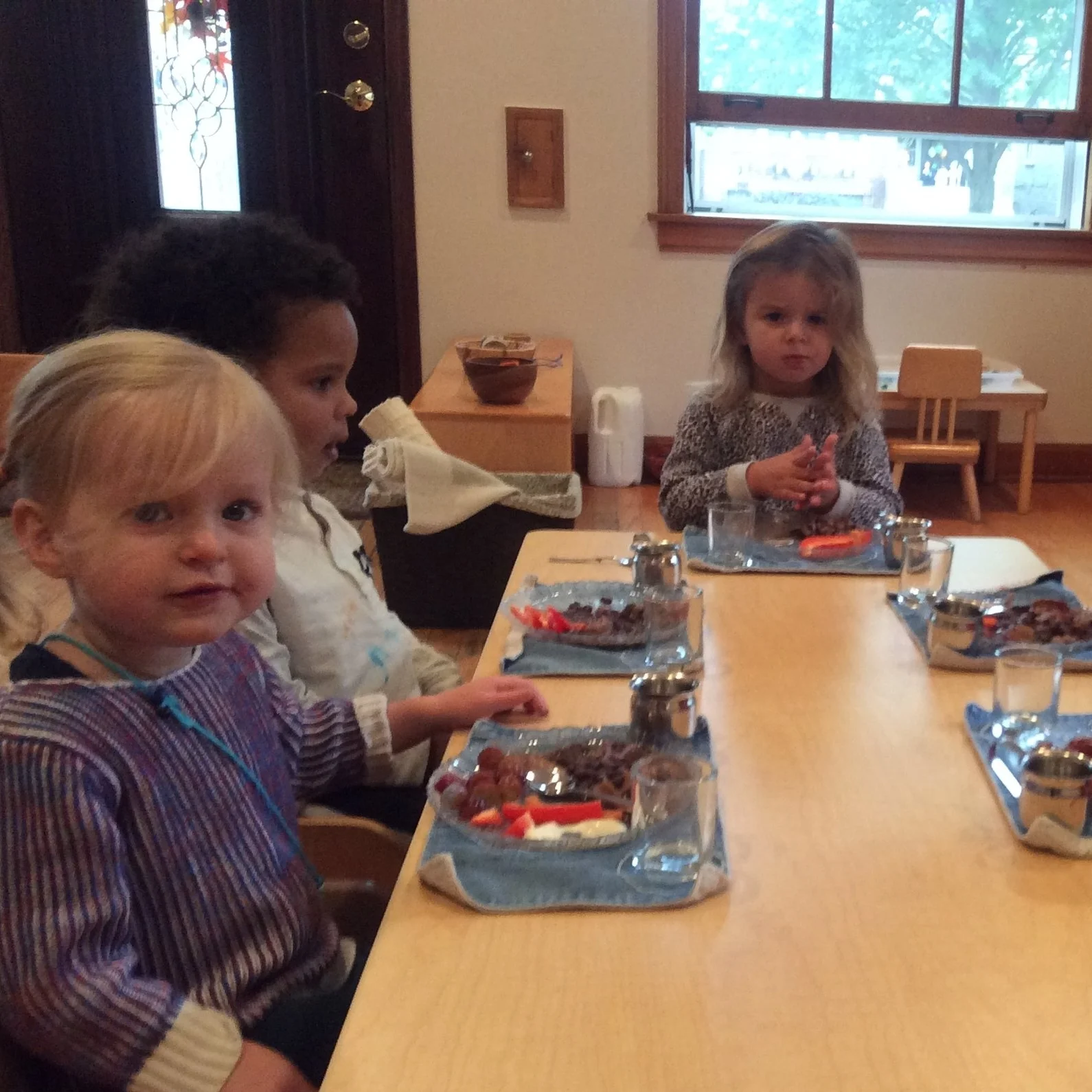 Children in both toddler and primary classrooms eat their meals at the table with a full table setting. 