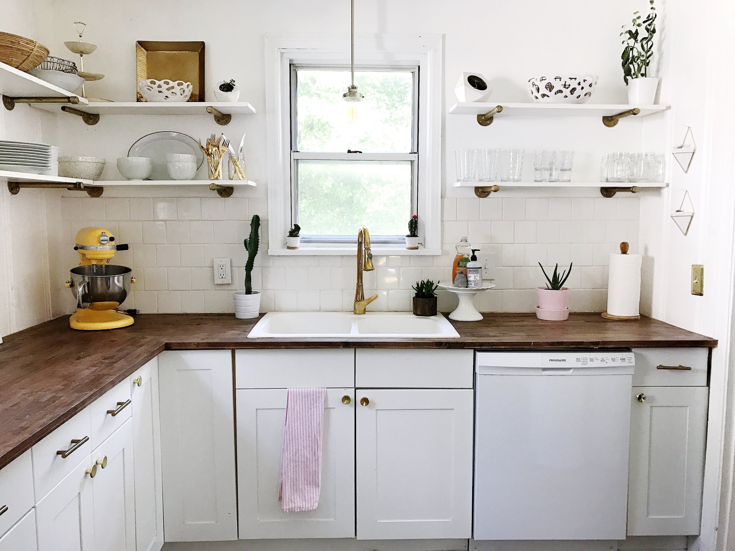 We loved the idea of open shelving. We are trying to adapt to a minimalist lifestyle, so we didn't need much cabinet space. We made our shelves out of galvanized pipe that we sprayed gold, and white pre-treated wood. 
