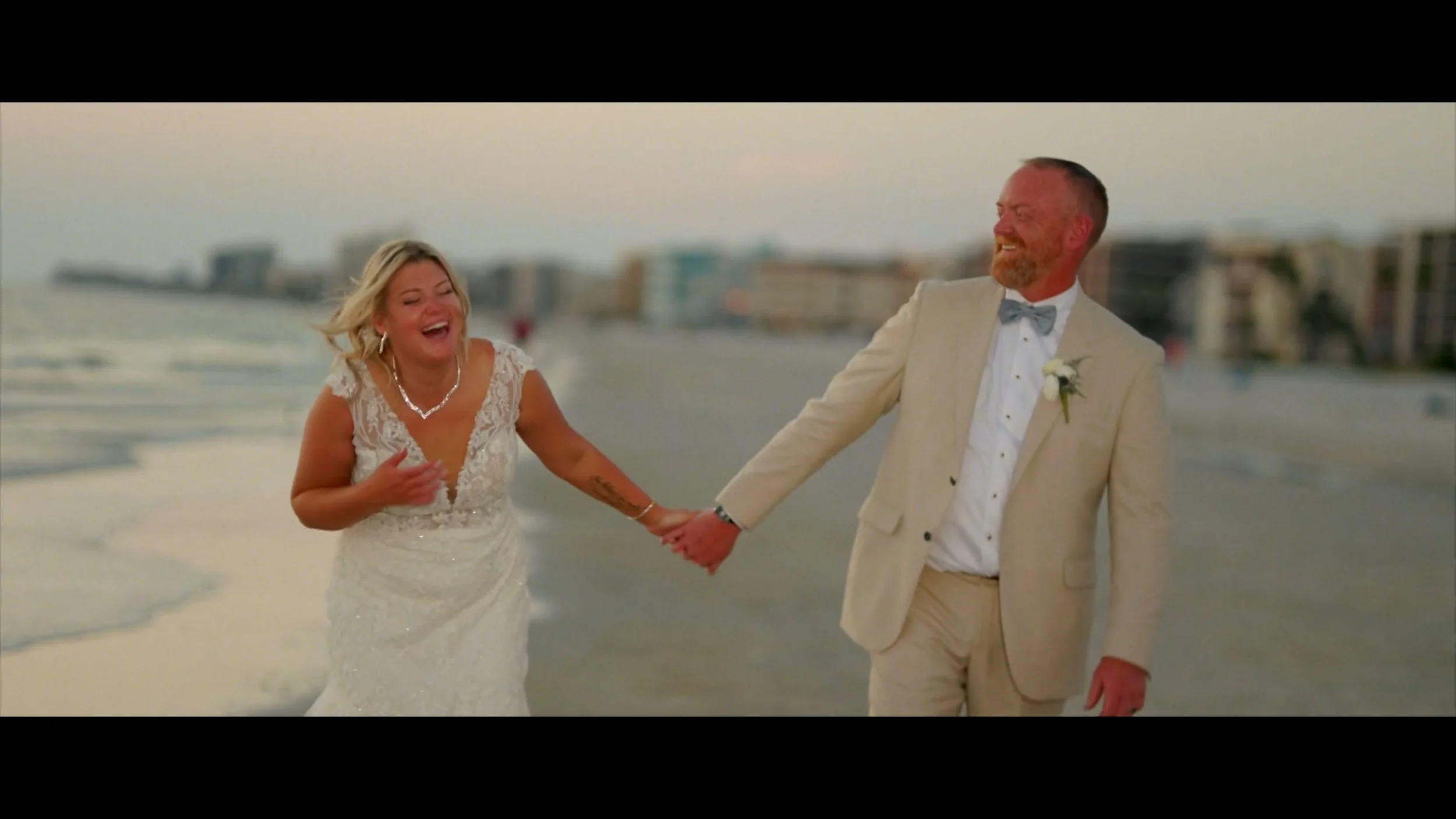 Couple holding hands on the shoreline at The West Events.