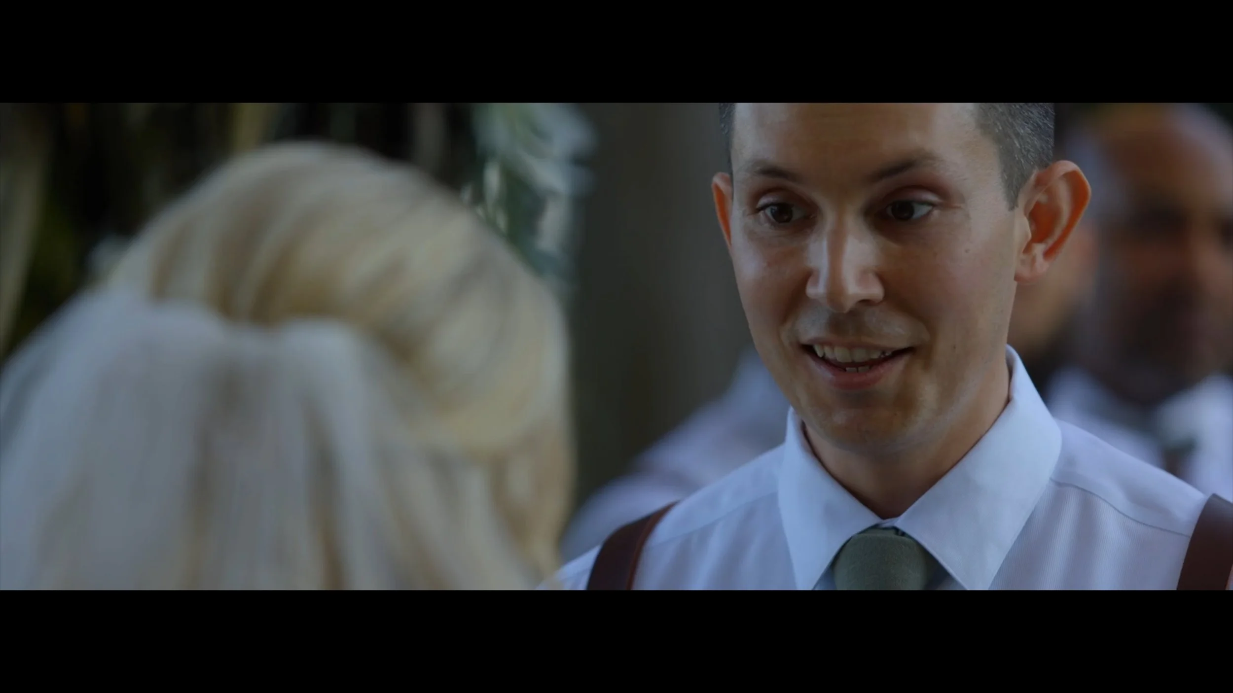 Groom exchanges his vows at knotted roots on the lake.
