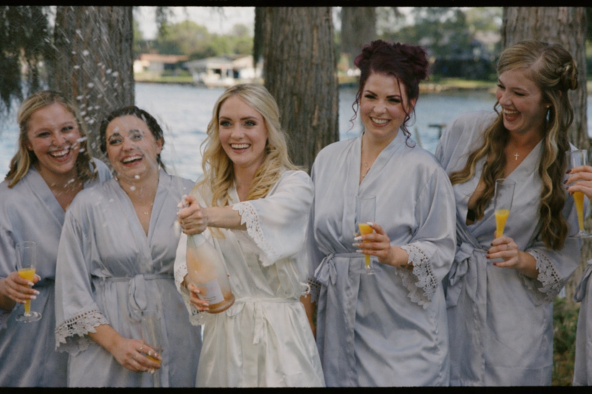 Bride celebrating with bridesmaids at Knotted Roots on the Lake wedding venue