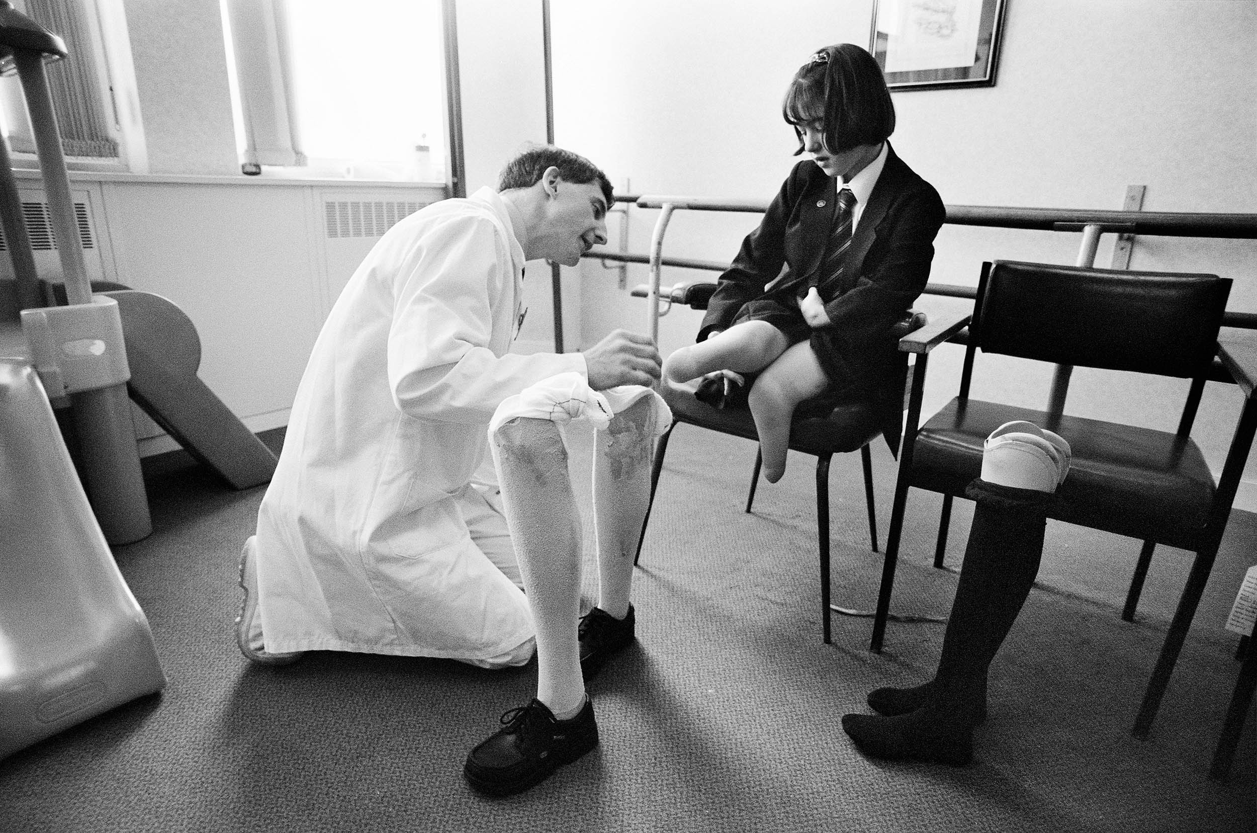  Schoolgirl being fitted with new artificial legs after growing out of her old ones. 