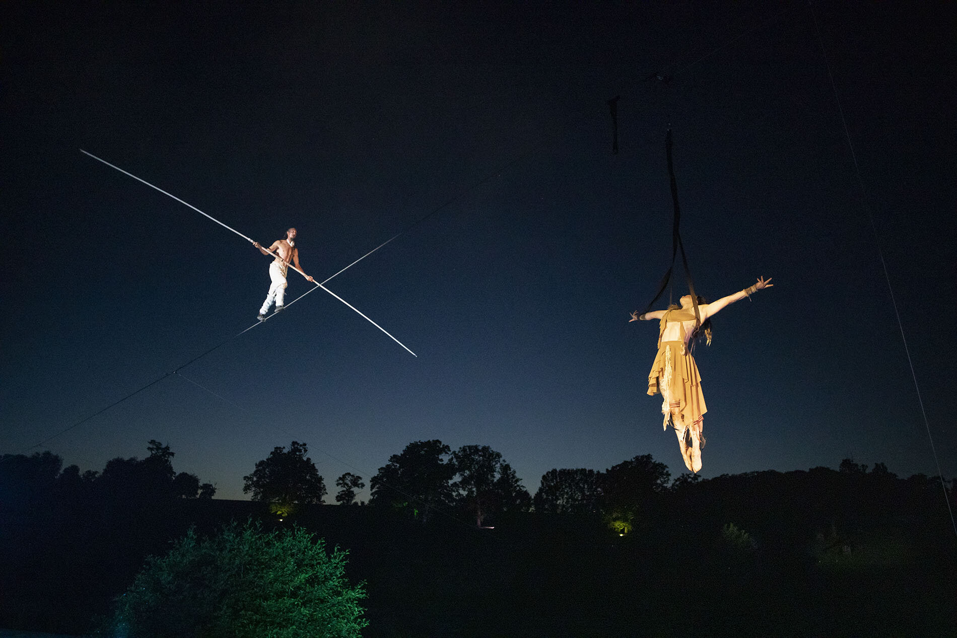 Tightrope walker Chris Bullzini and aerialist Eloise Currie performing at Compton Verney Gardens, Warwickshire.