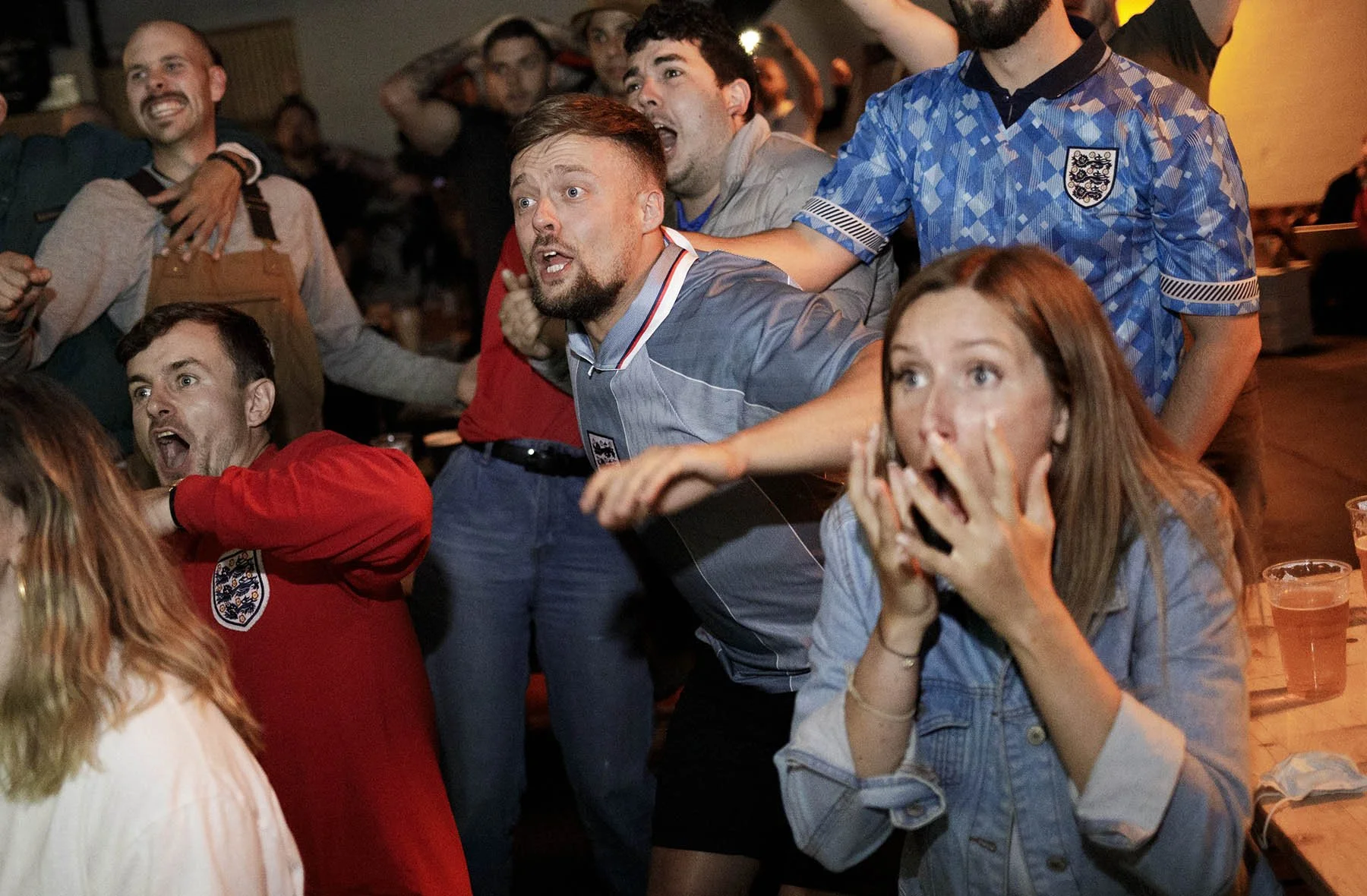  England fans in a pub react while watching the Euro 2020 semi-final against Denmark  