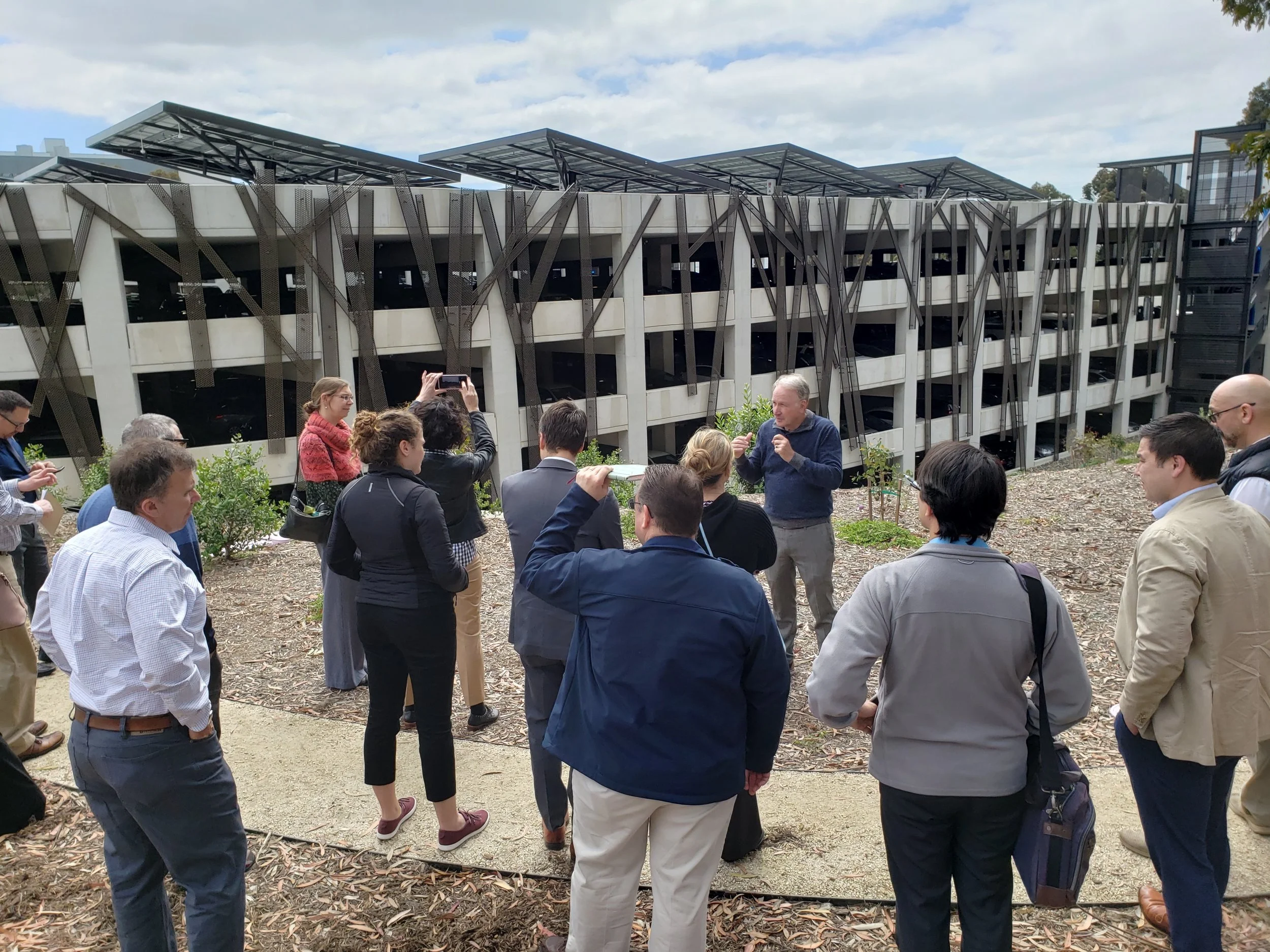 Dr. Byron Washom explains the value of mounted solar arrays, vehicle charging infrastructure, and their connection with the UCSD microgrid to the MERC Cohort at this parking facility.