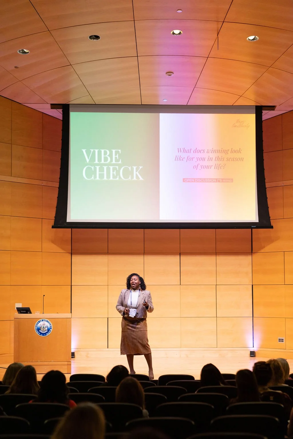 Conference speaker standing on stage presenting to the audience