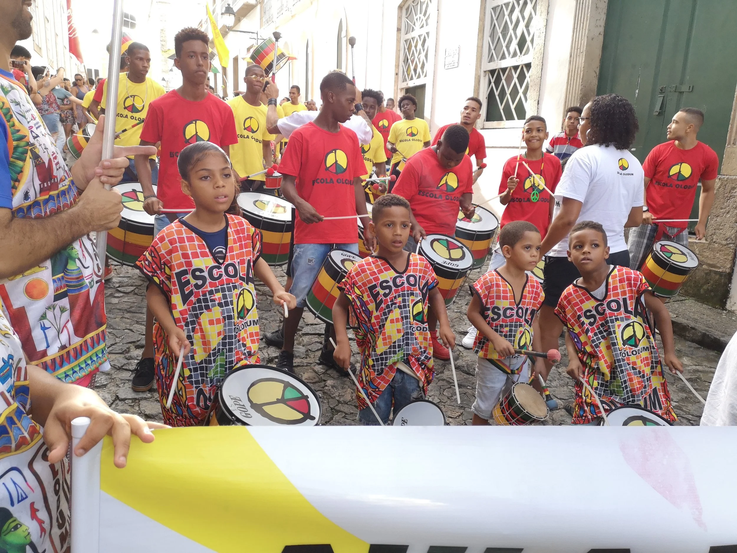 Marching through the small alleys of Pelourinho with some of the students of Escola Olodum .