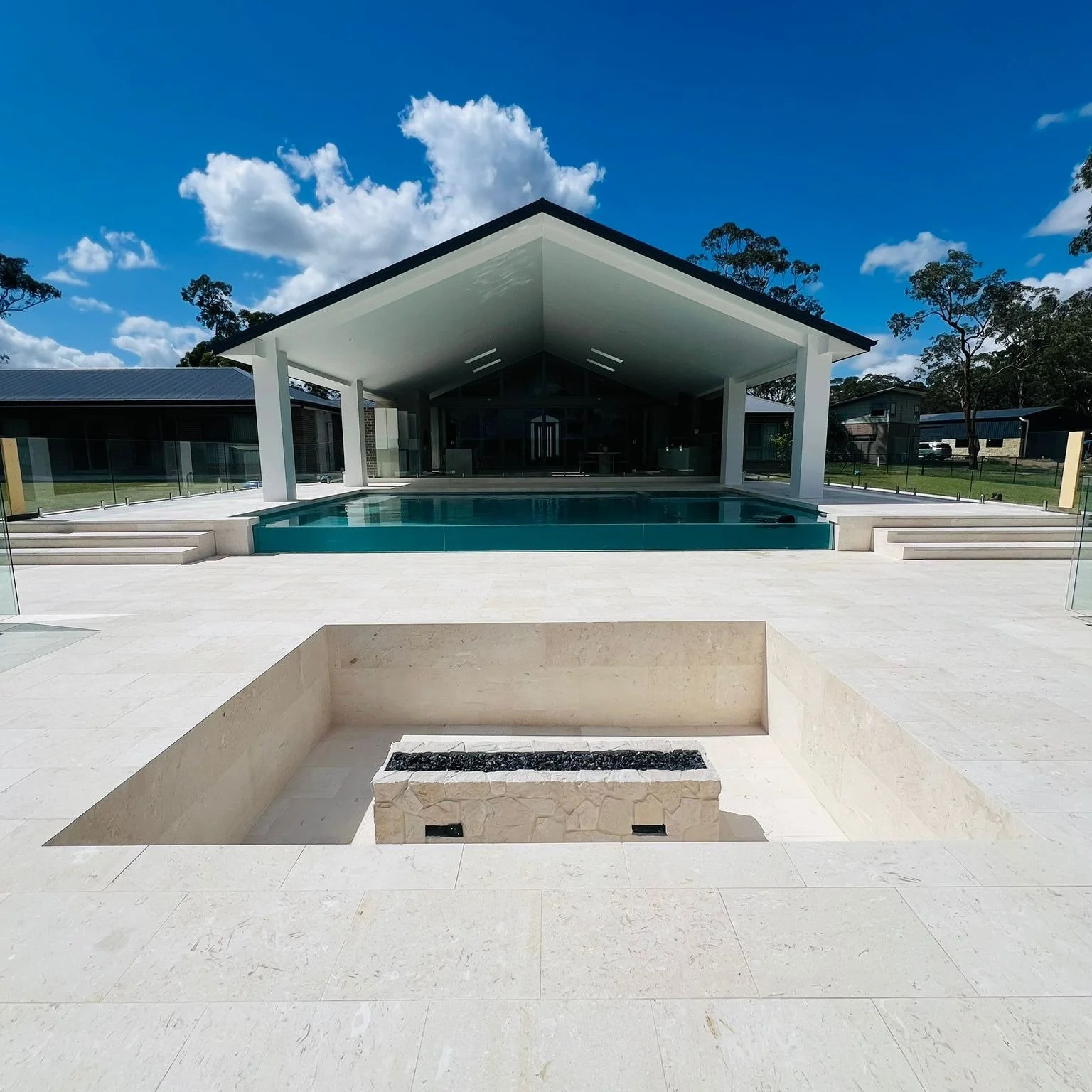 Resort-style family pool featuring a fully tiled finish, integrated spa, and elegant glass wall for a luxurious and enjoyable outdoor experience.