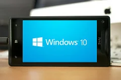Windows phone laying on its side, with windows logo in white on a blue background.