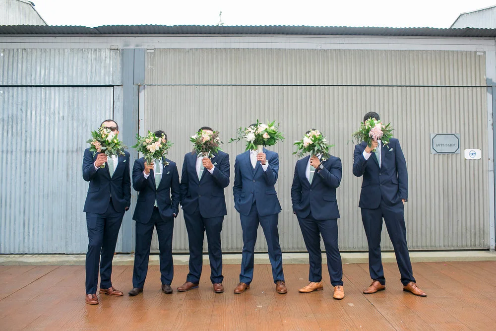 b9453-elegant-country-charm-ranch-wedding-groomsmen-being-silly-with-bridal-bouquets.jpg