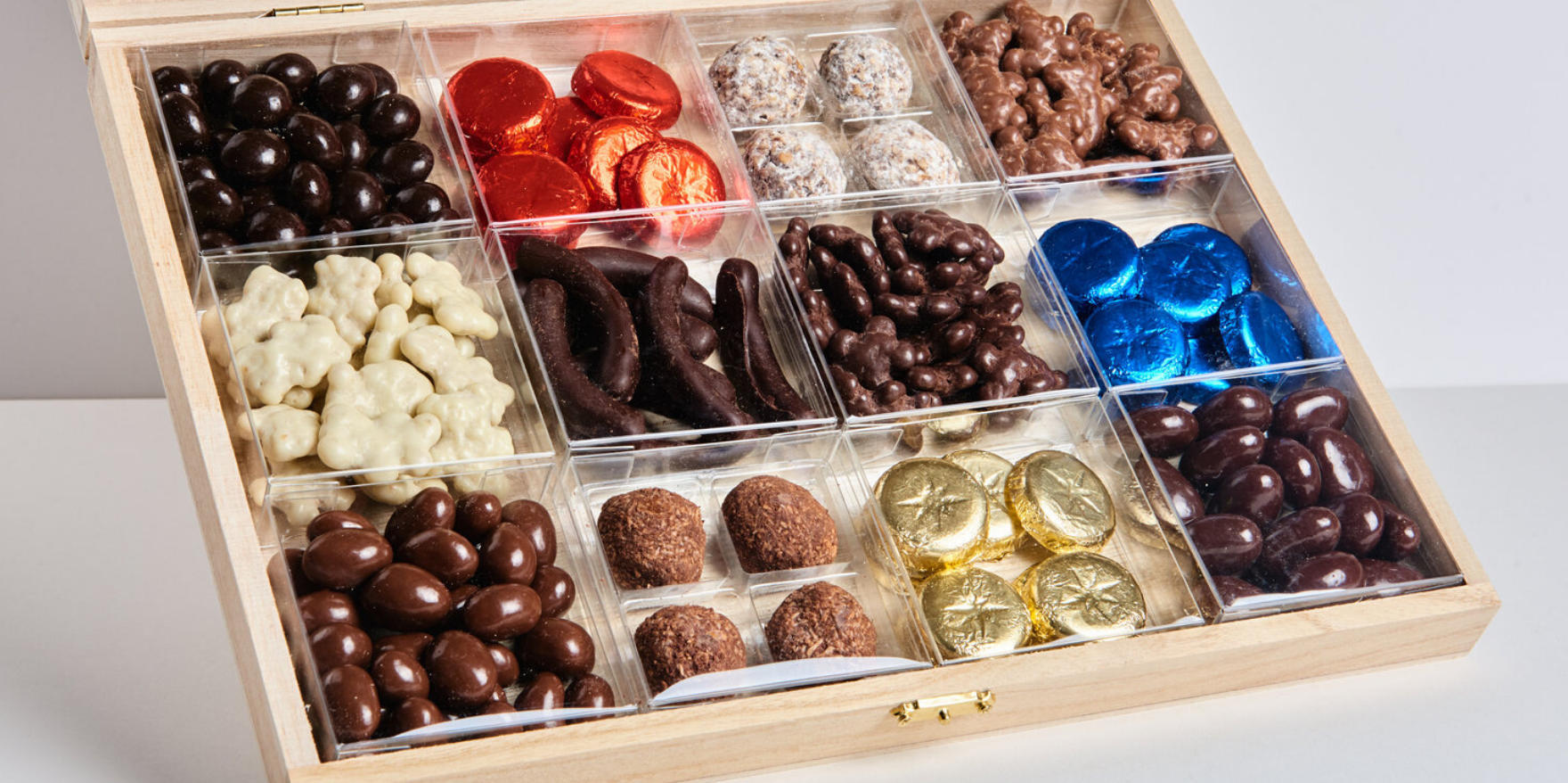  Rectangular wooden assortment box of twelve clear boxes each holding one type of chocolate 