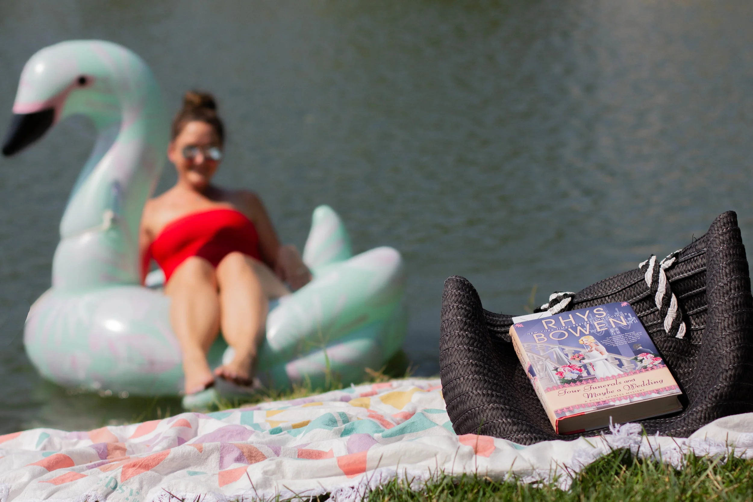 Reading Four Funerals and Maybe a Wedding by Rhys Bowen on the lake at New Town in St. Charles