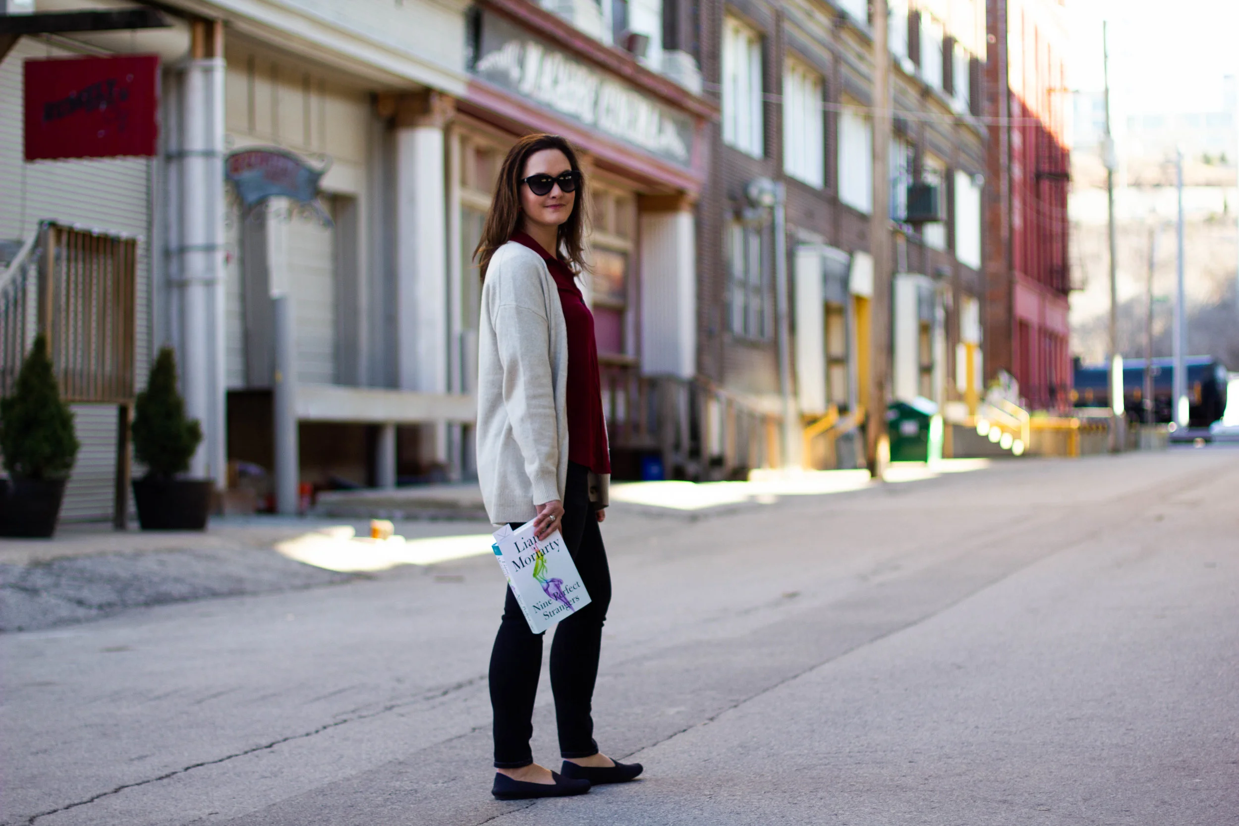 Reading Nine Perfect Strangers by Liane Moriarty in the Historic West Bottoms district of Kansas City, MO