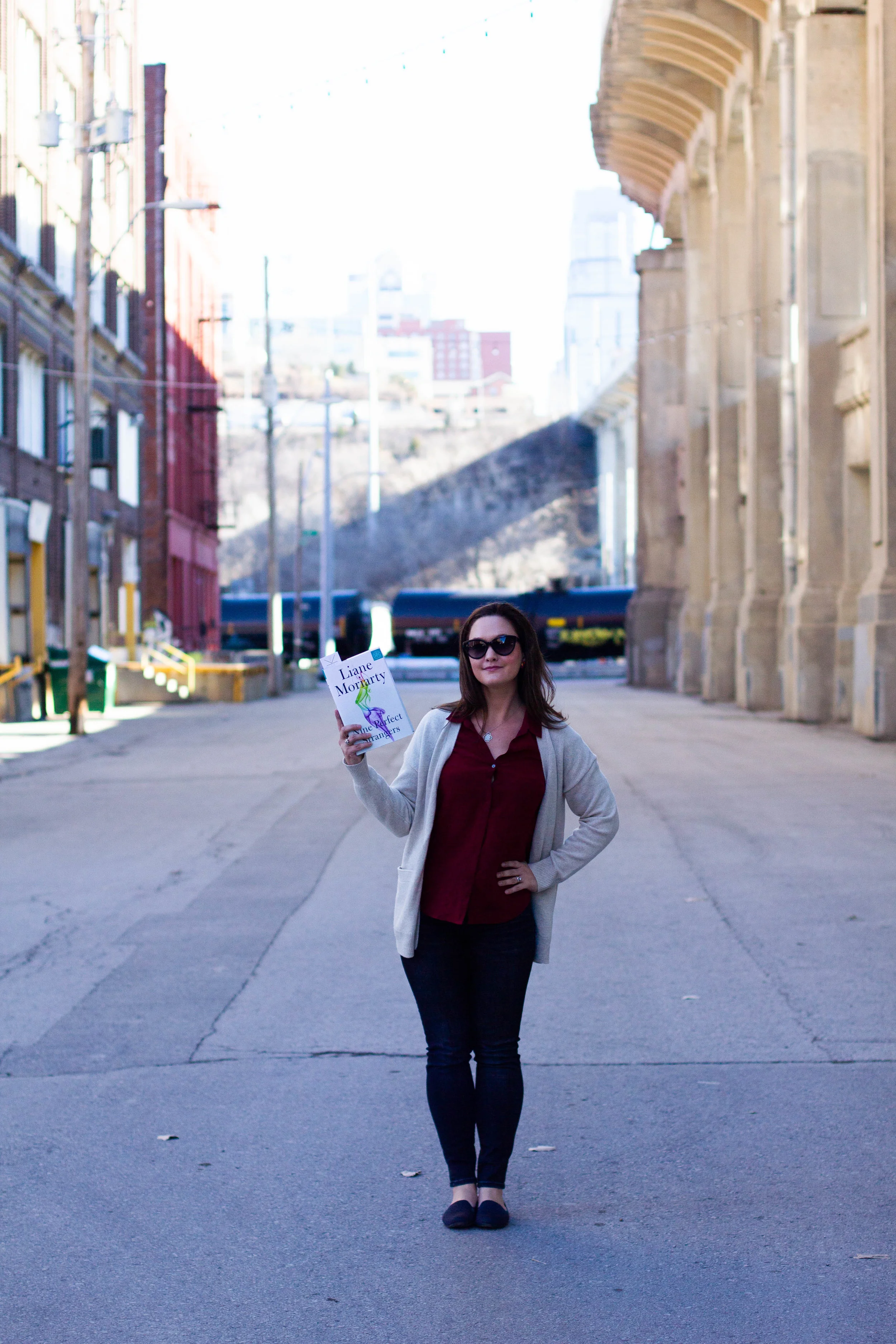 Reading Nine Perfect Strangers by Liane Moriarty in the Historic West Bottoms district of Kansas City, MO