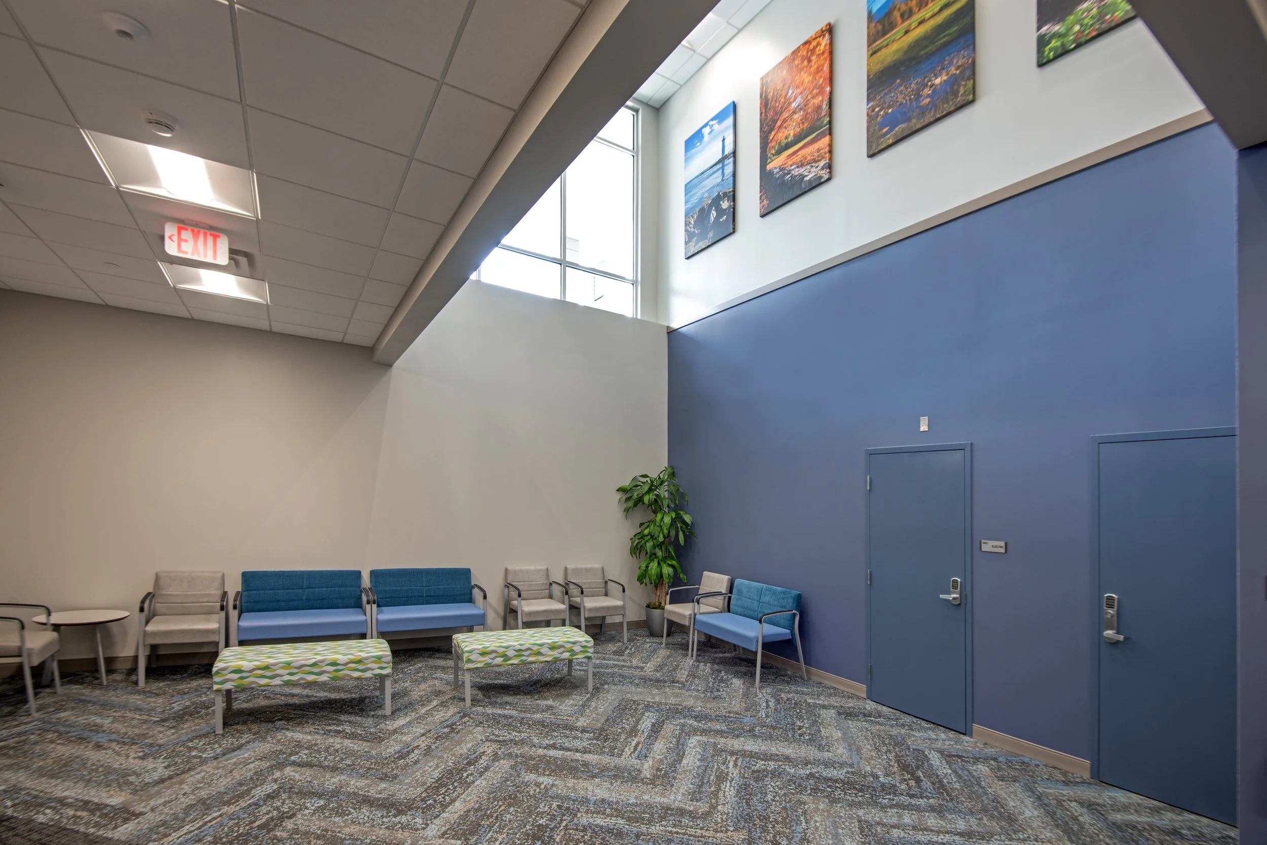 lobby for medical center with vaulted ceilings, art, and natural light