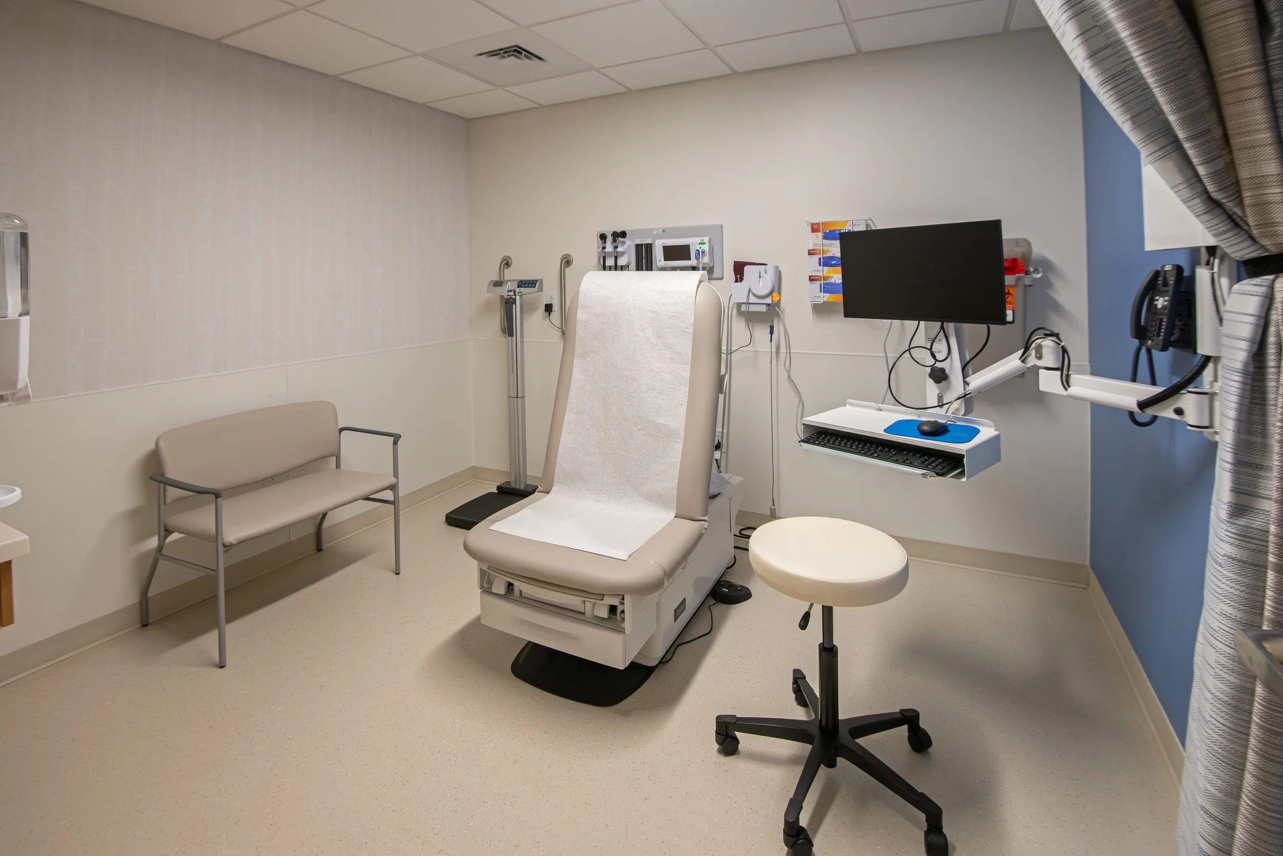 medical exam room with chair and medical devices
