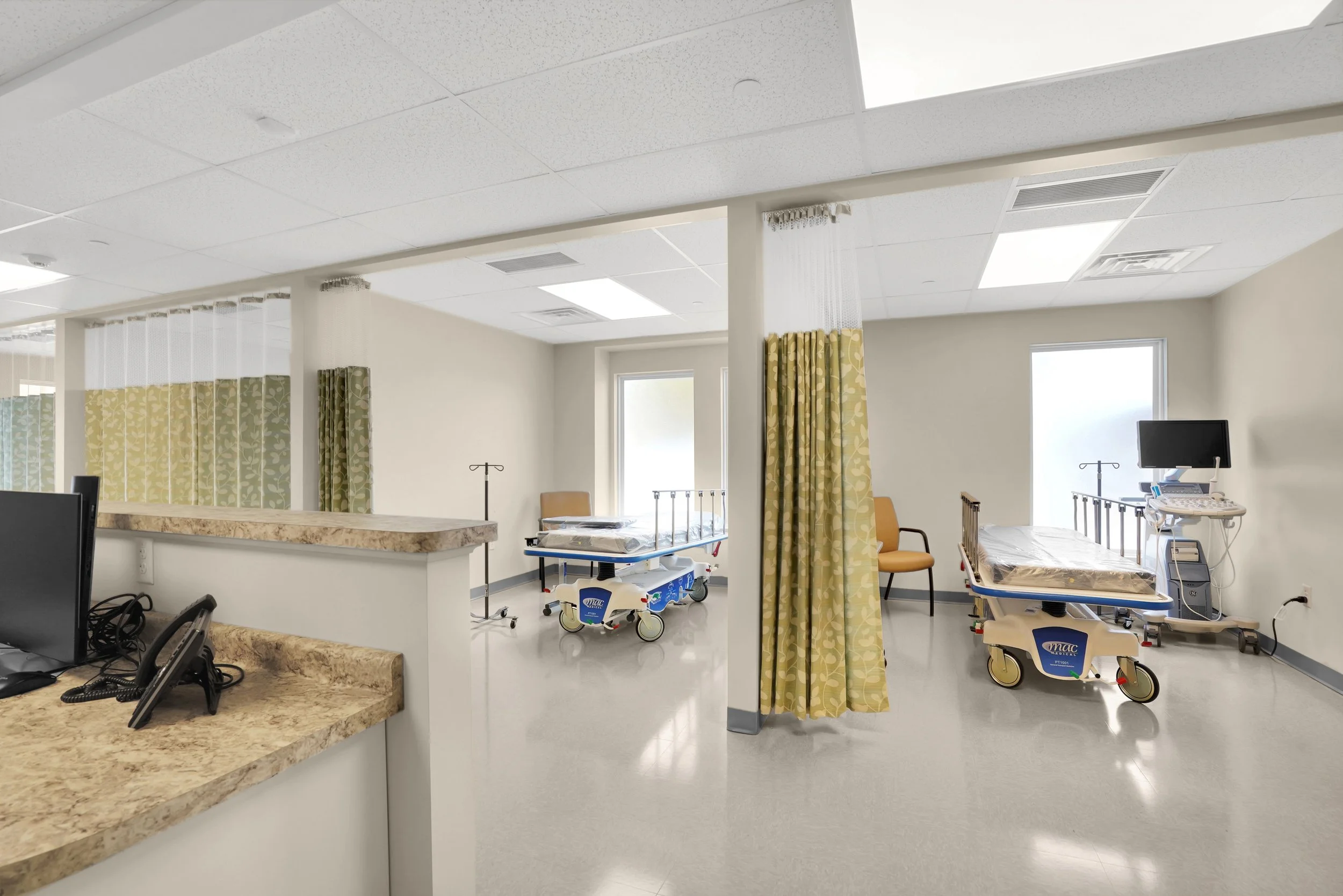 emergency department rooms with curtains and gurneys