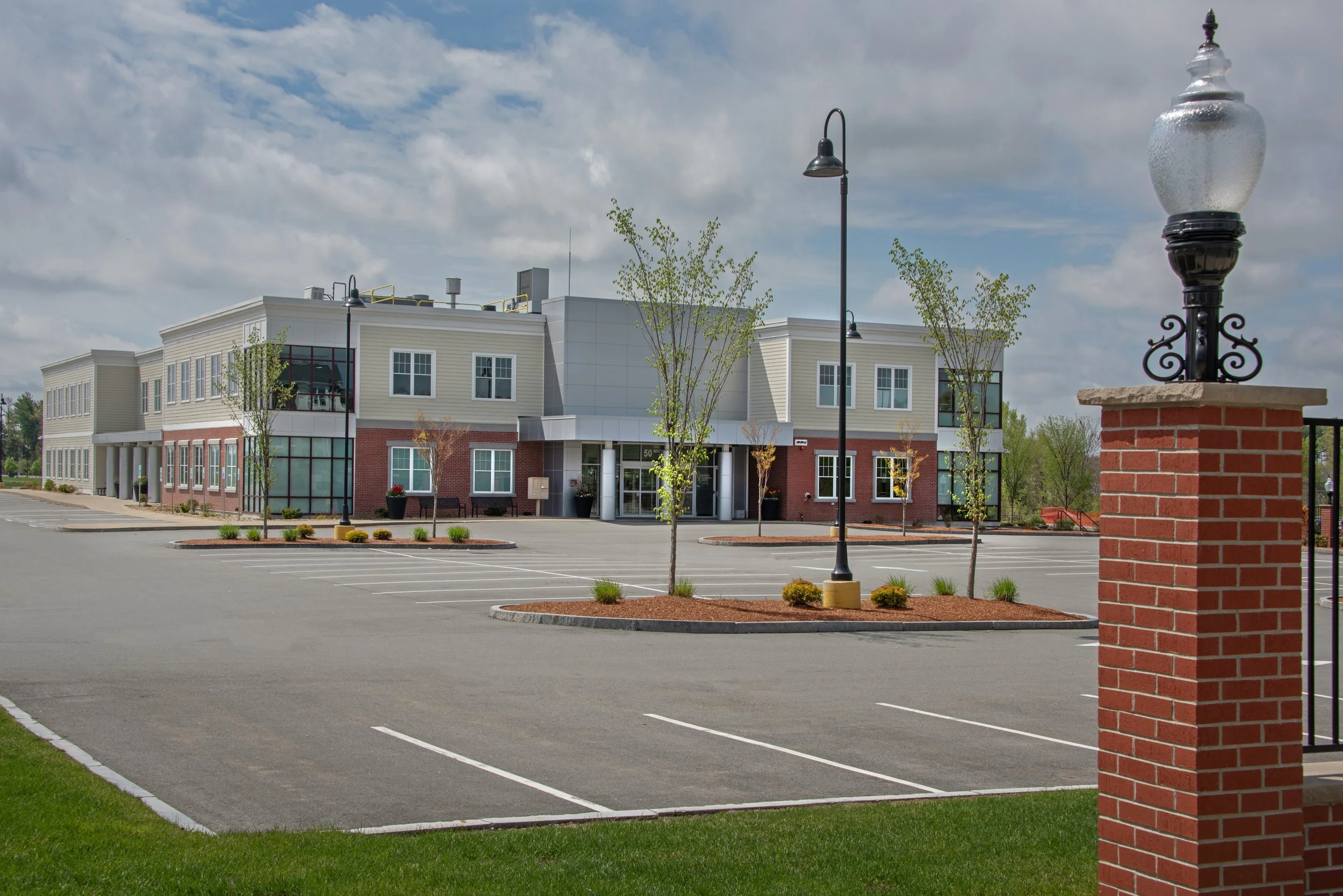 modern building exterior in background with brick lamp post in foreground