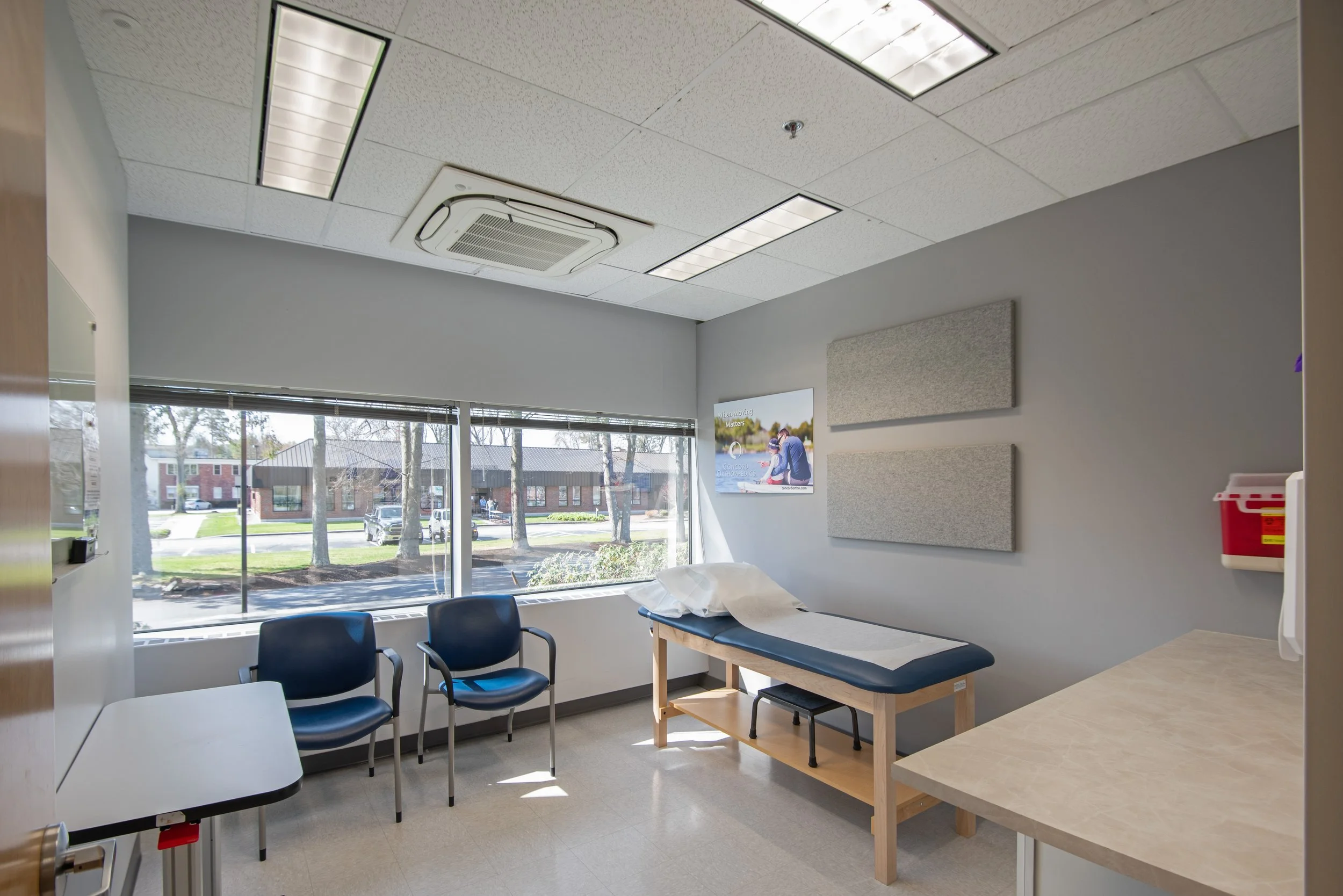 patient exam room with bed, chairs, and counters