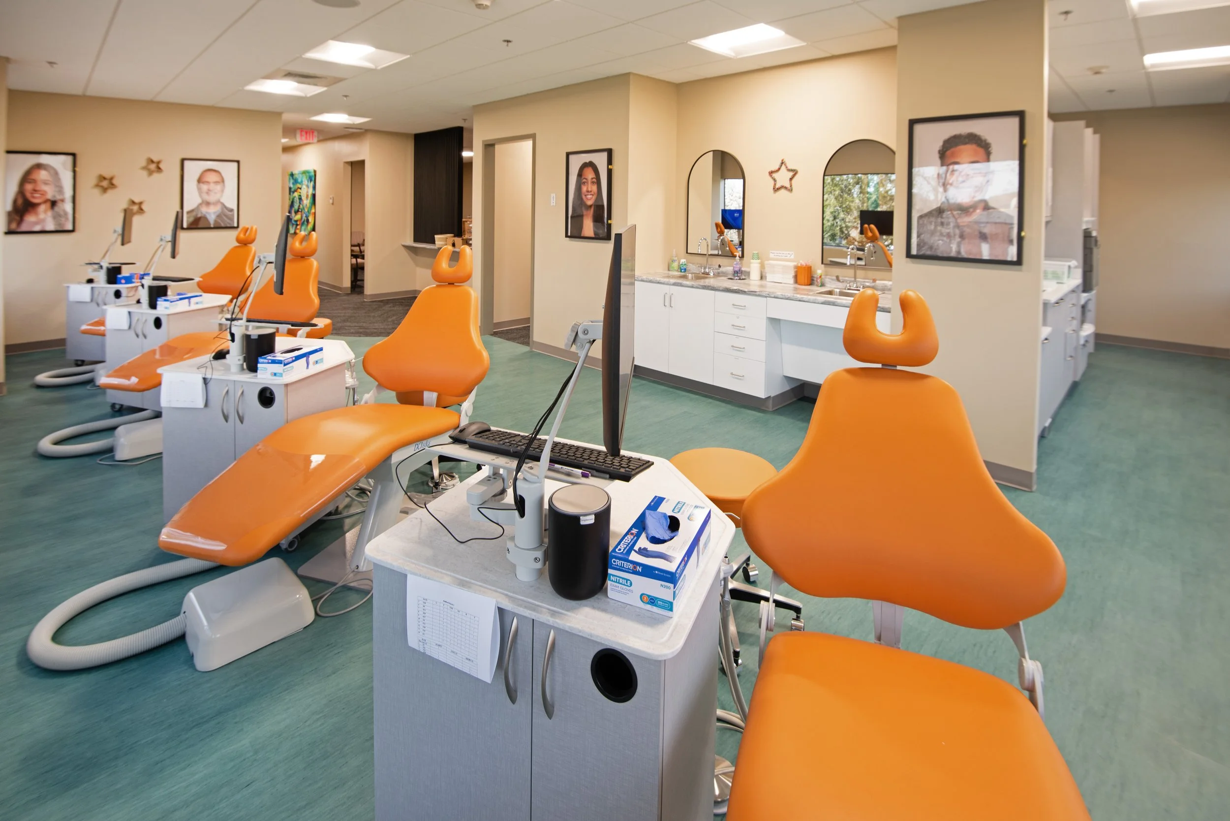 orange orthodontist chairs in open concept treatment space