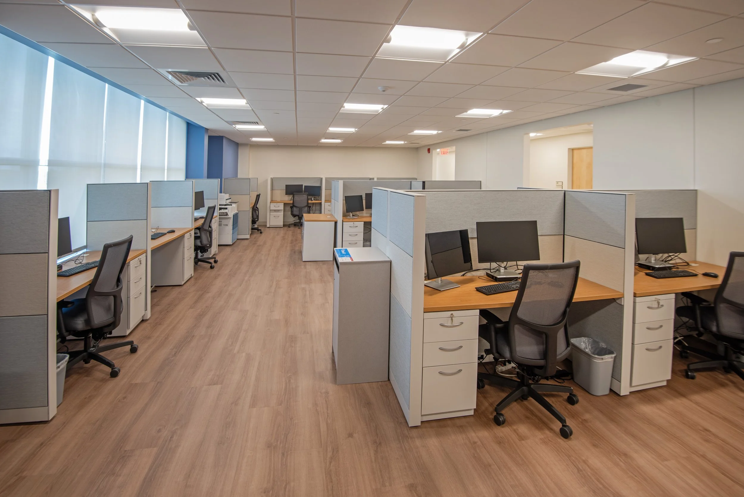 small cubicles with multiple desks and computers
