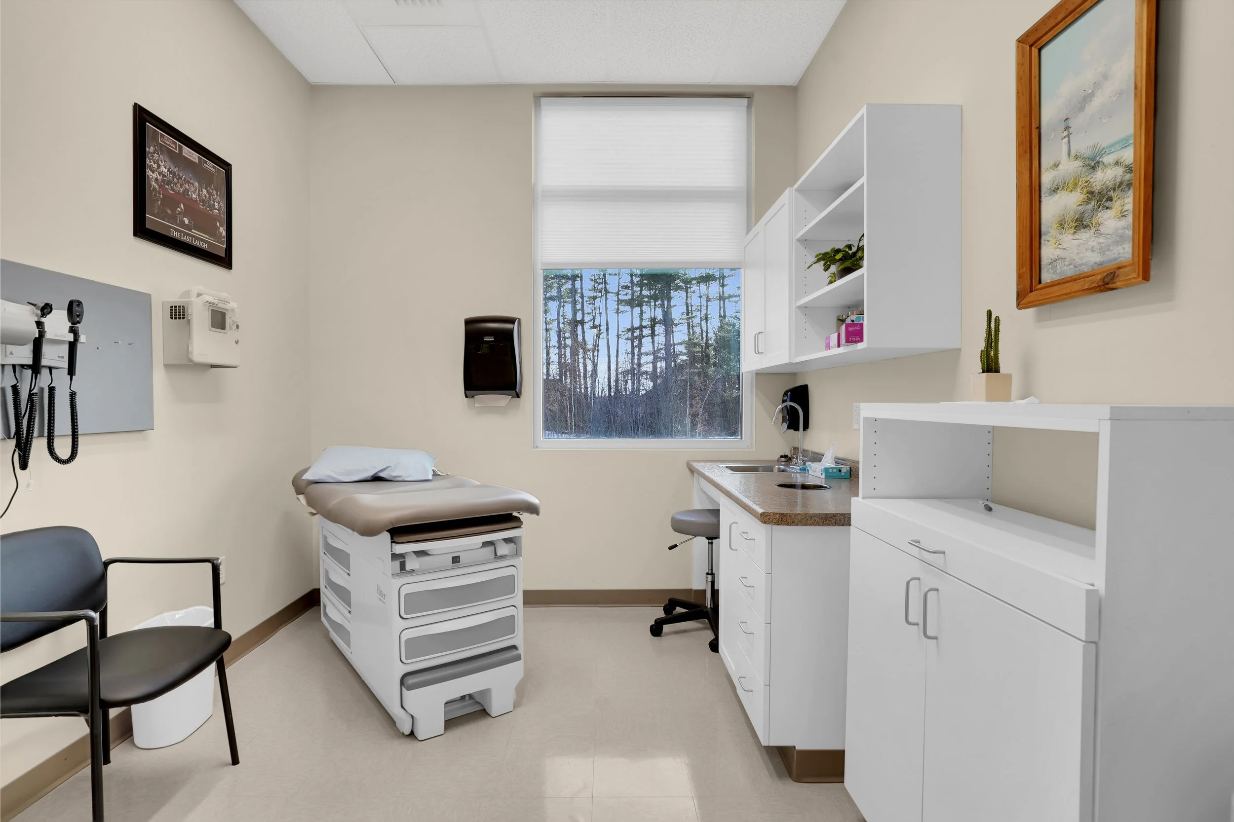 Patient exam room with exam table chairs and cabinets