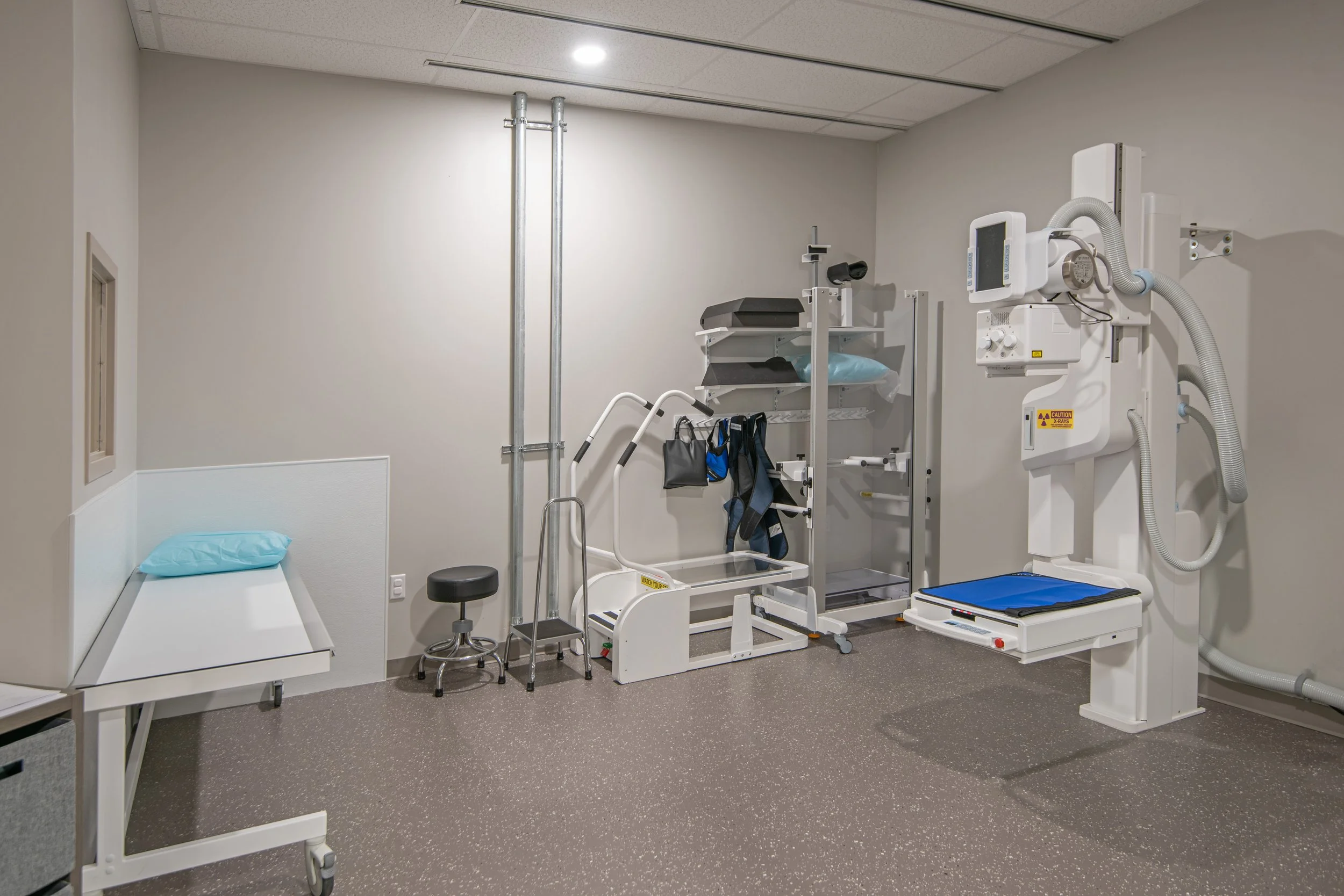 xray room with imaging machine and patient bed