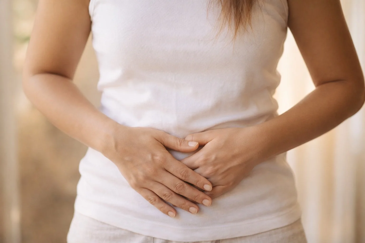 Frau legt Hände ruhig auf den Unterbauch – Symbol für Darmgesundheit, Histamin und hormonelles Gleichgewicht in den Wechseljahren