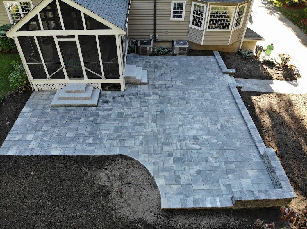 New paved patio in backyard with retaining wall.JPG