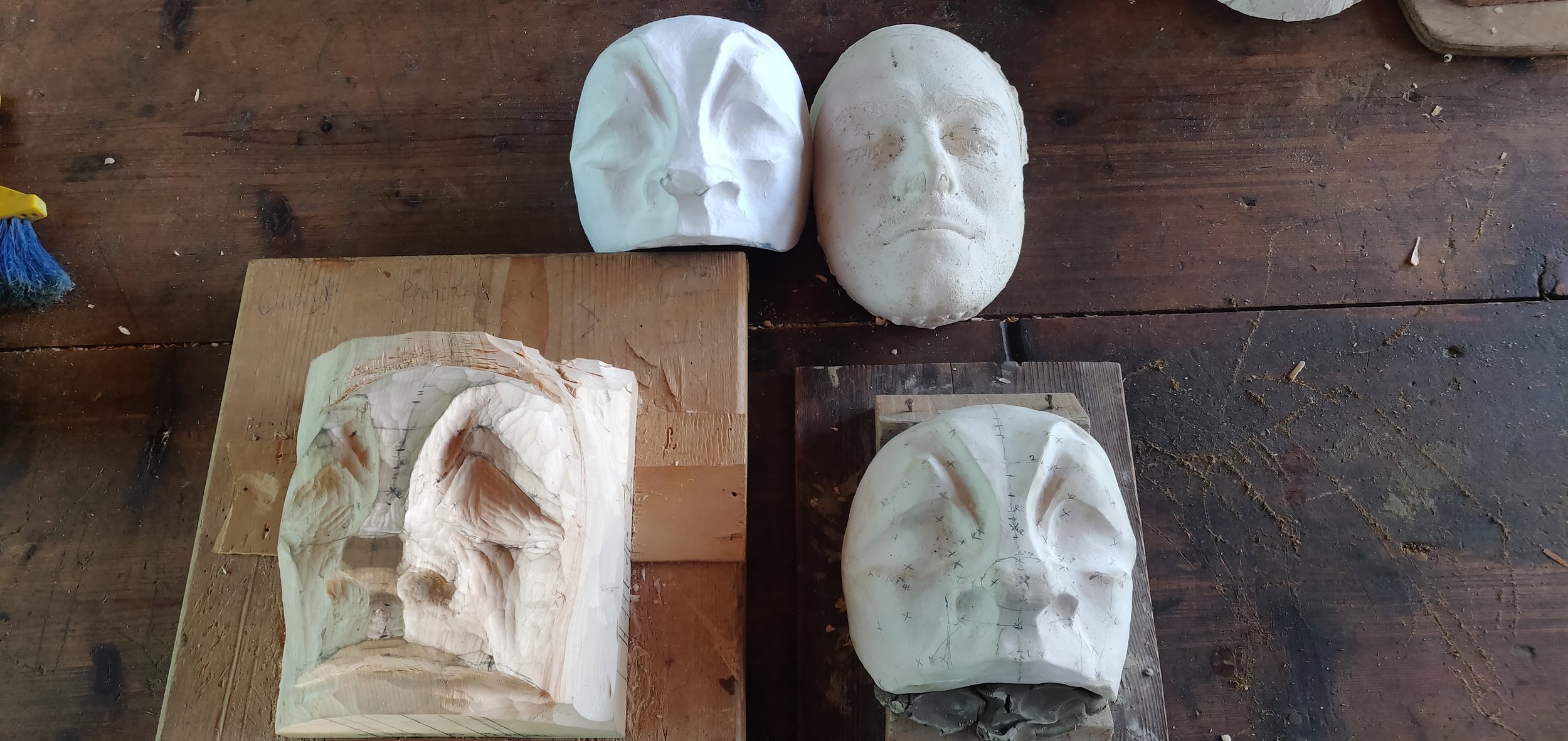 Wood carving in progress with plaster positive and papier mache mask