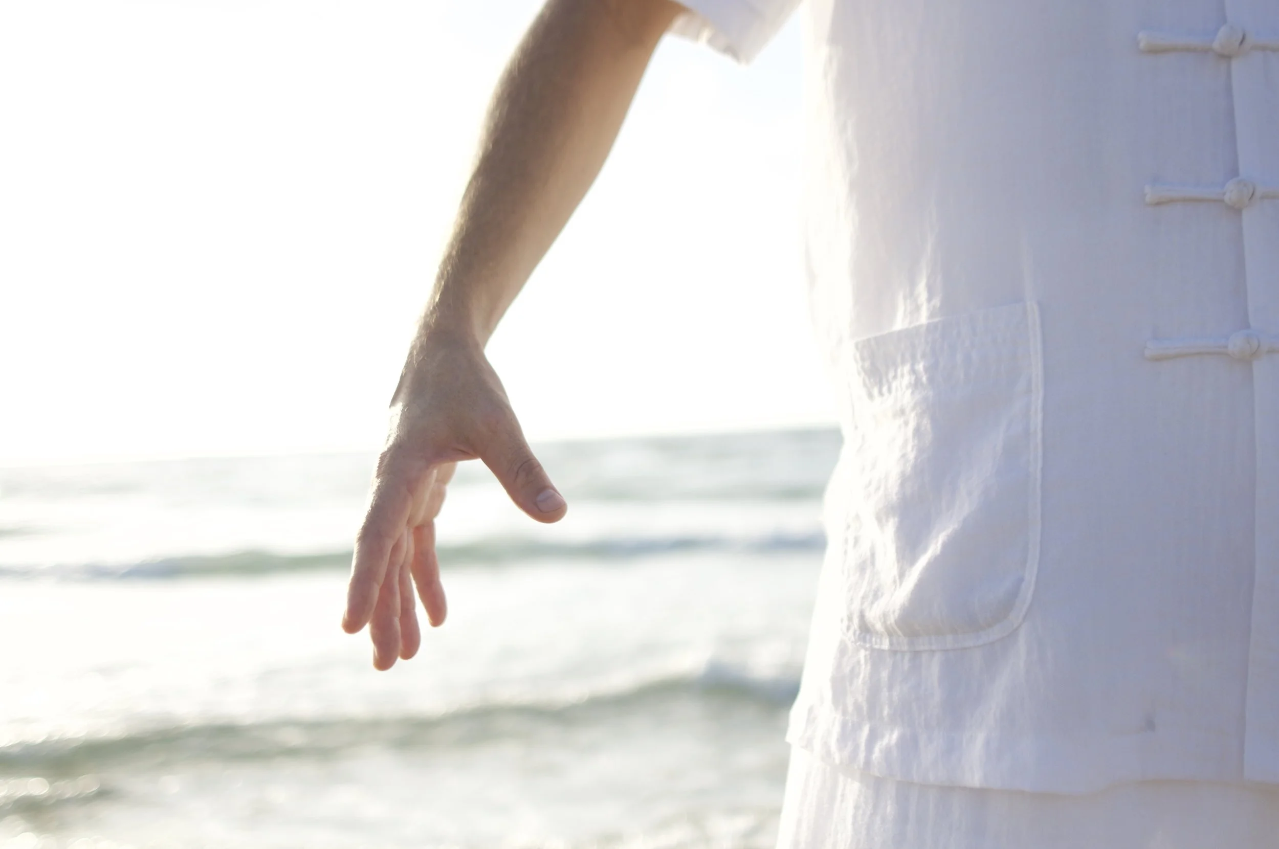 A man performing qi gong on the beach