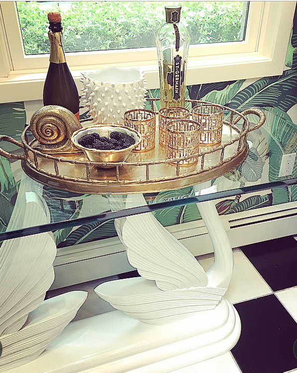 Pool house Bar Set up at the Barnhouse. Mostly vintage with a little bit of newness. Wallpaper, Martinique; Swan Console, Vintage. Brass Bamboo Tray, Vintage. Brass snail, vintage. Vintage Culver "Imperial Shoji" glasses available via Garland Maison (info@garlandcollection.com). Bowl, L'Objet . Vase, Jayson Home .