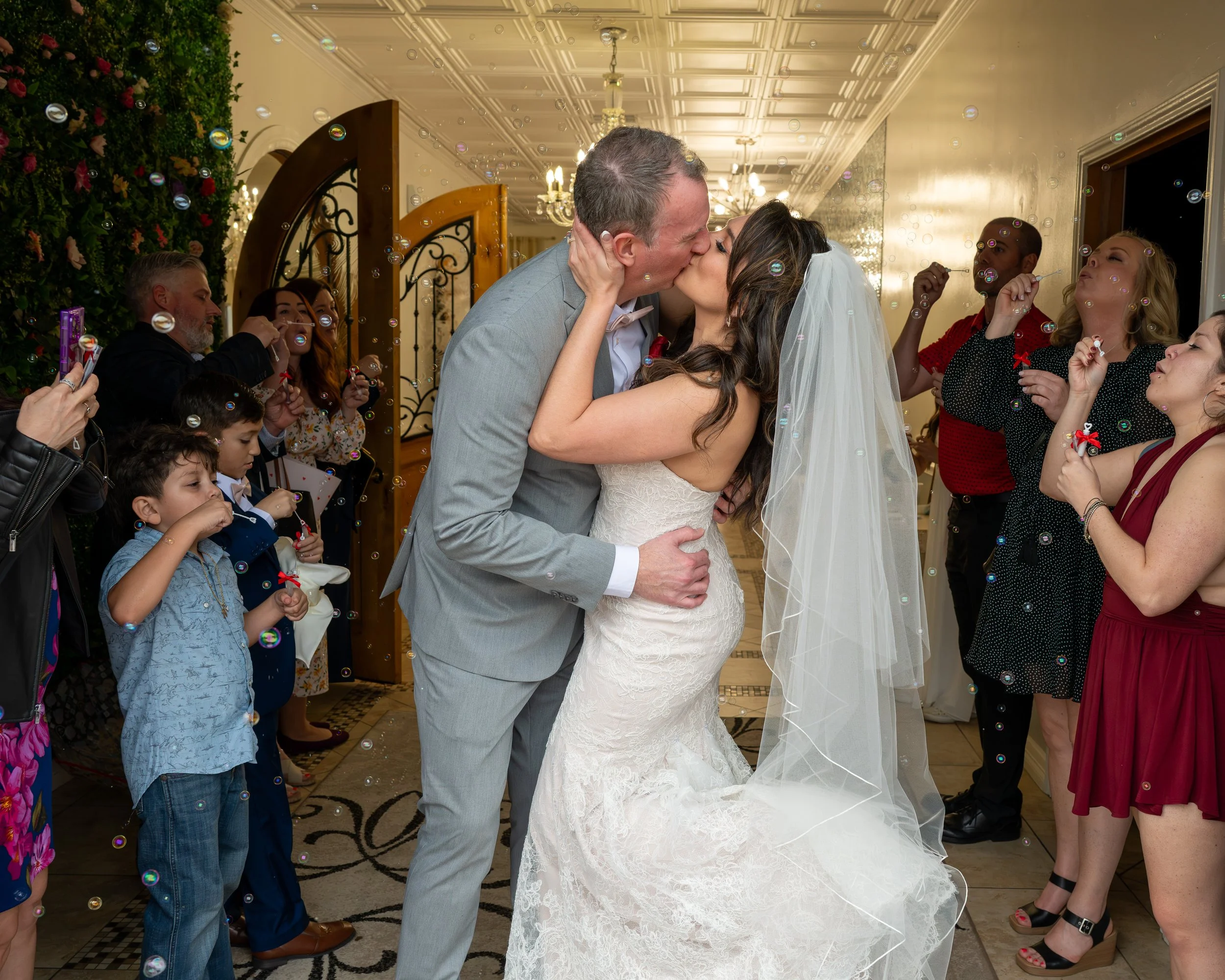 Couple Kissing as family celebrate their love surrounded by bubbles