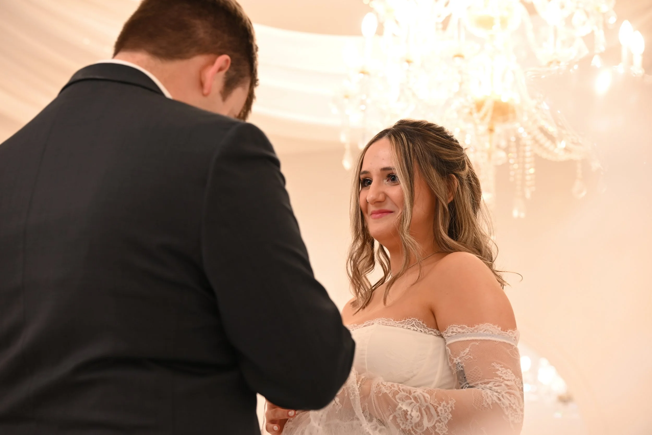 bride radiating joy under chandeliers at Feragne Villa