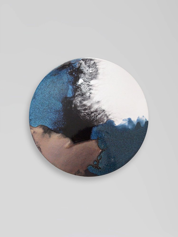 Abstract circular artwork with blue, black, white, and beige splashes and textures.