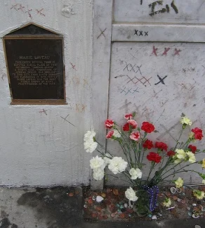 Marie Laveau’s tomb is covered with the letter “X”— the beads and flowers are offerings by visitors