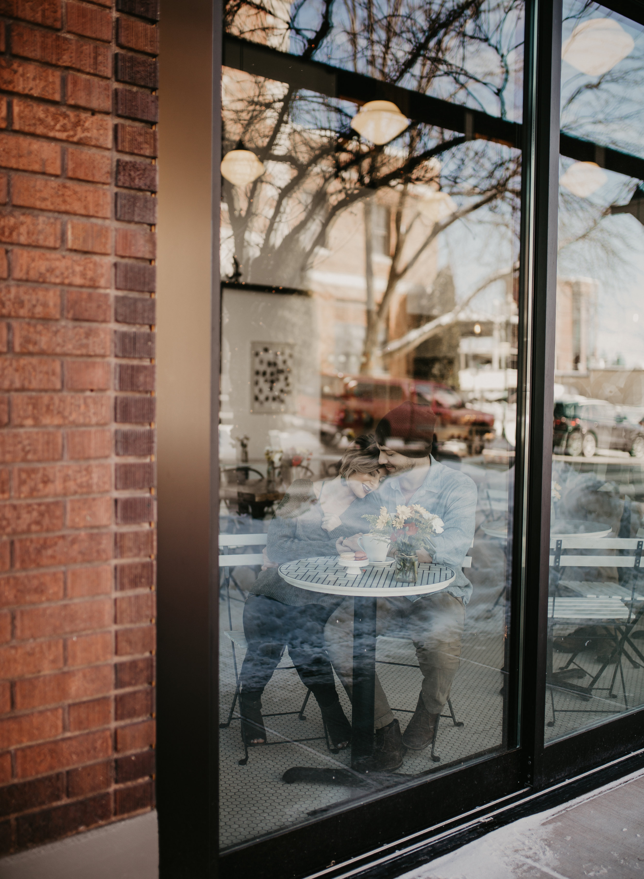  Couple snuggling during engagement session in a downtown CDA coffee shop engagement session 