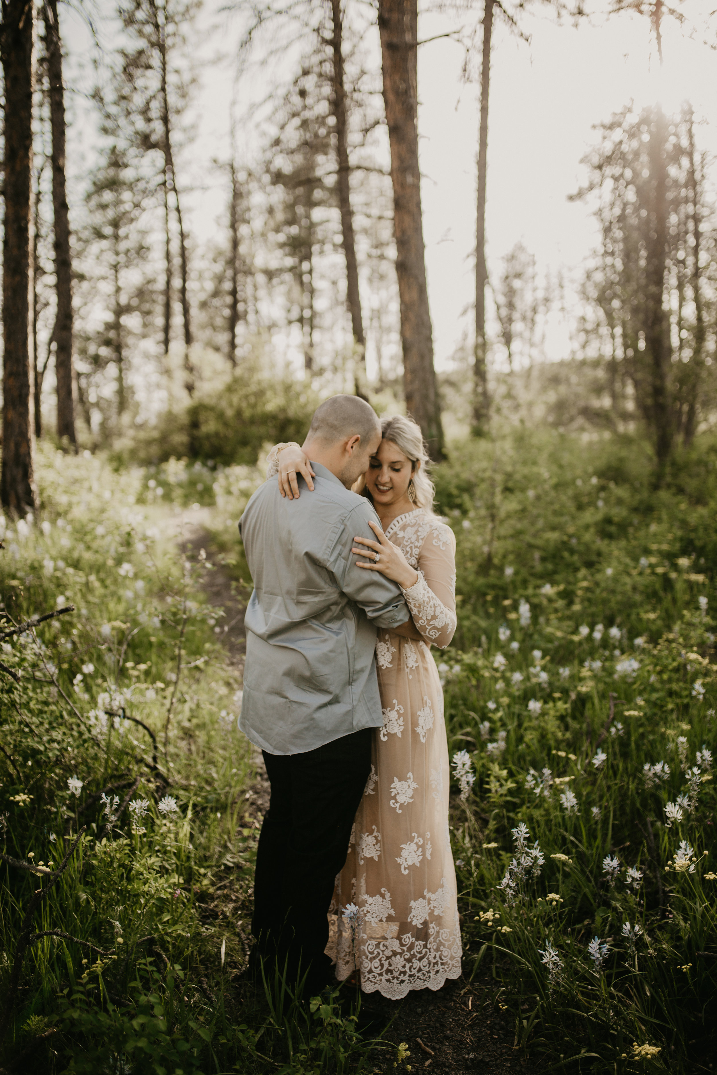  fiance giving his soon to be bride a hug in a field of wildflowers 