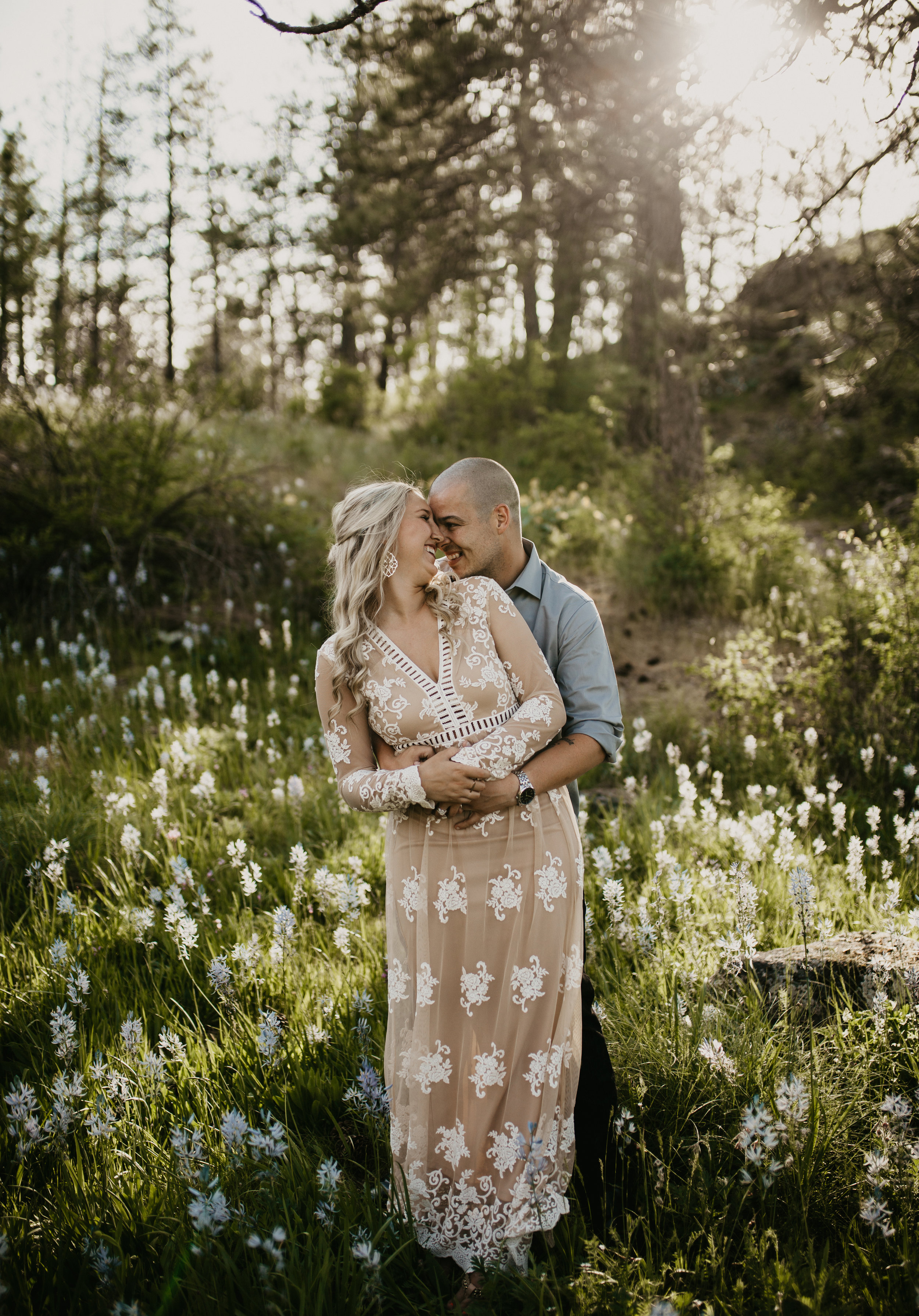  Engaged couple hugging during photoshoot in a field of wildflowers 