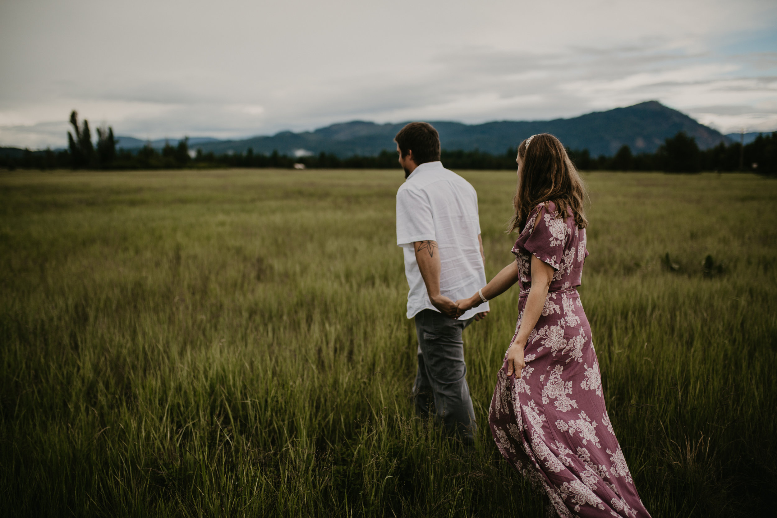  Bride and Groom walking in a North Idaho field holding hands 