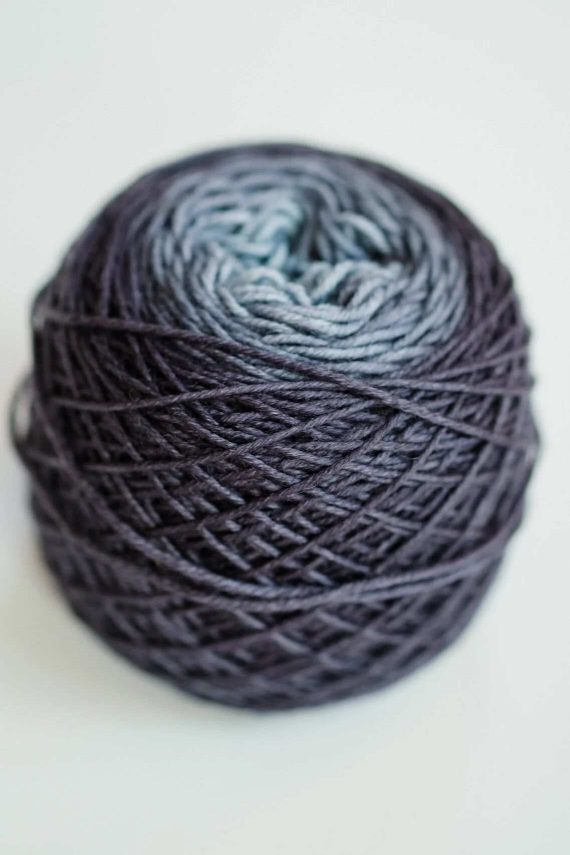 A ball of yarn that fades from dark blue on the outside to light blue on the inside.