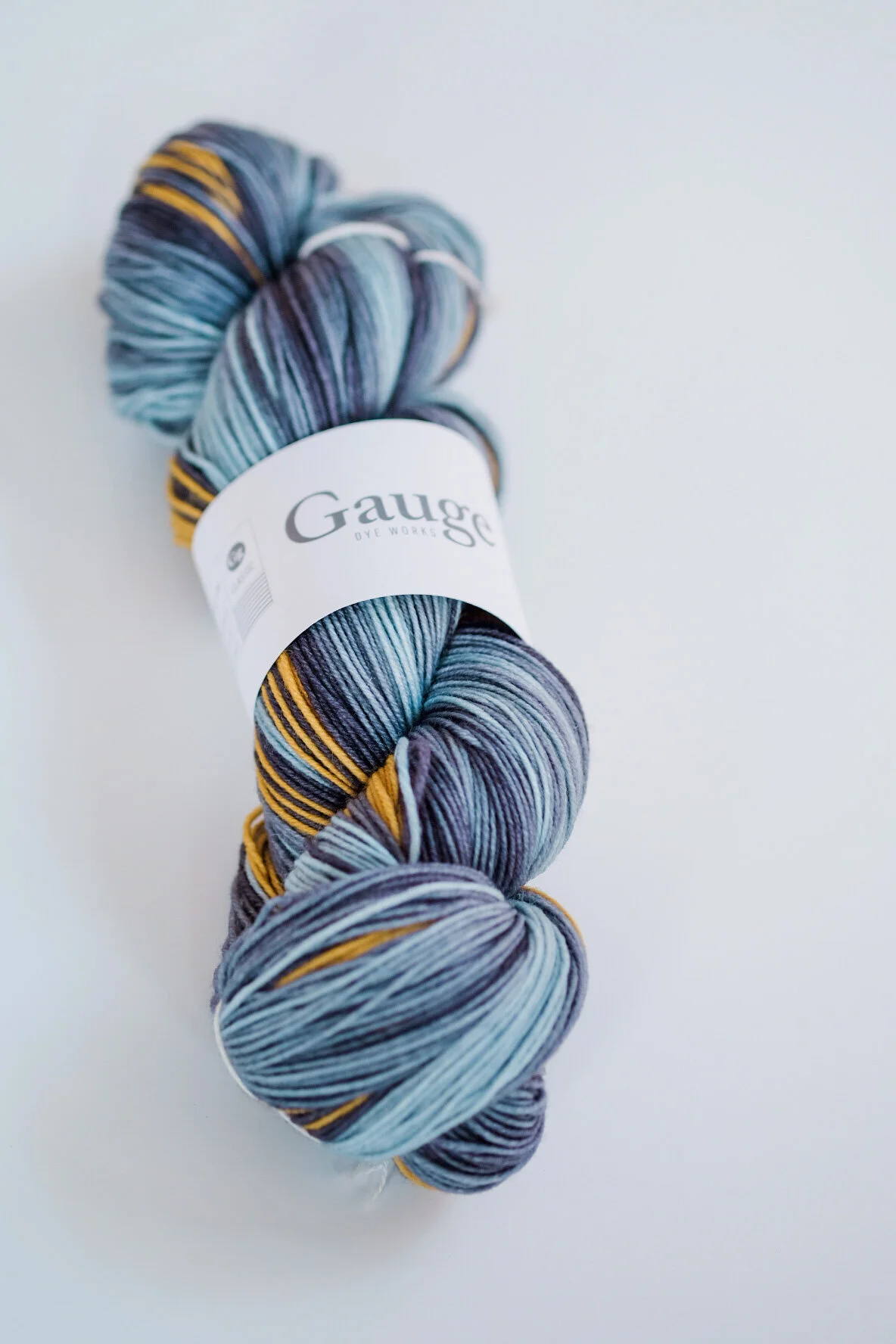 A skein of Gauge Dye Works CLASSIC Self-striping Merino Twist yarn in the Sun colourway.