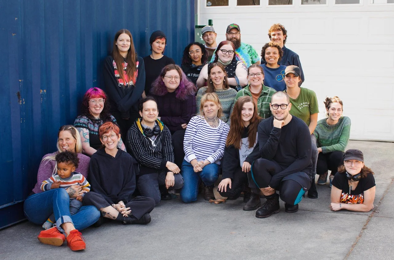 A group shot of the Spincycle crew posing together outside their building.