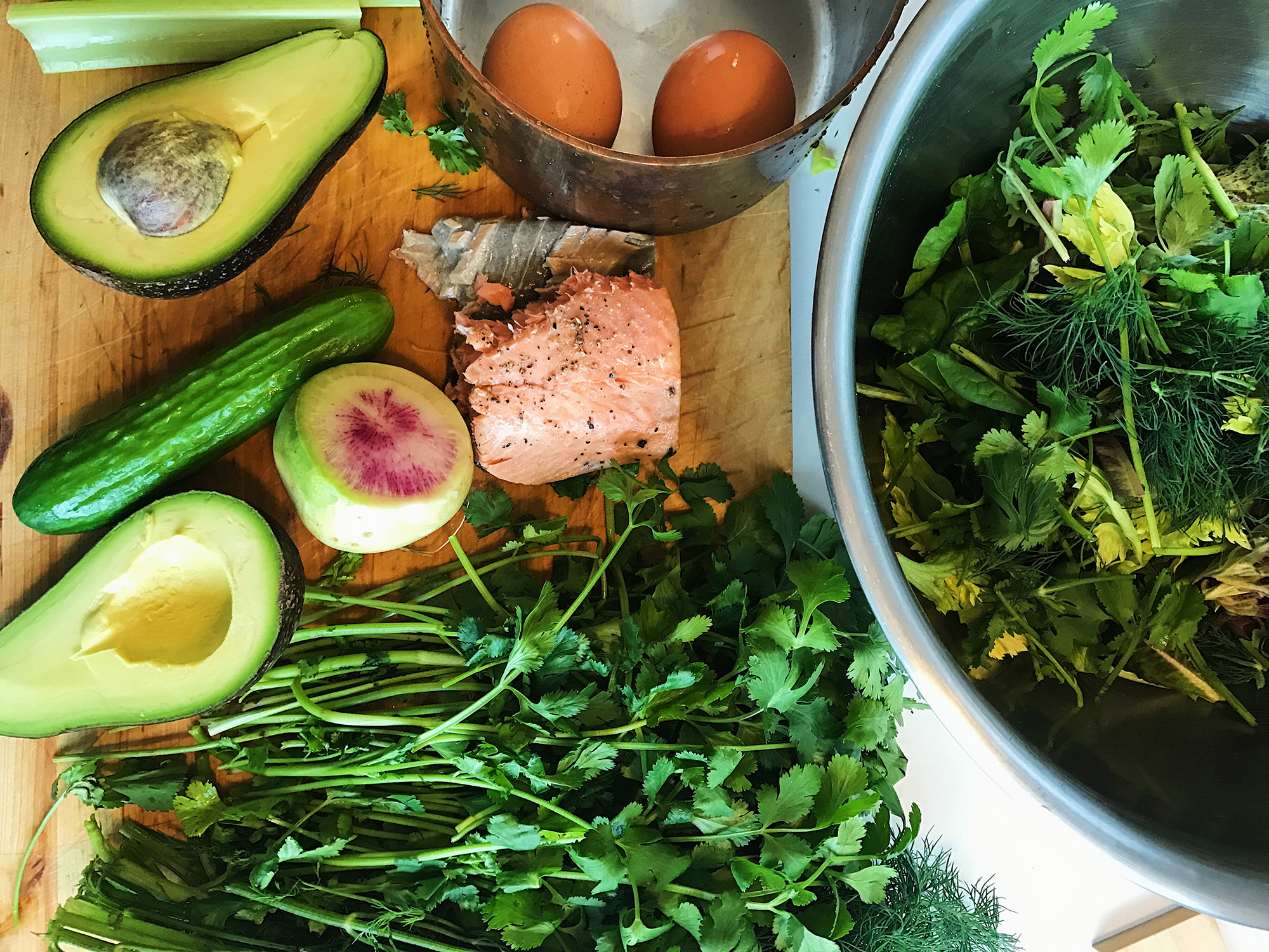 Kitchen counter filled with power foods avocado and salmon for a simple and healthy salad