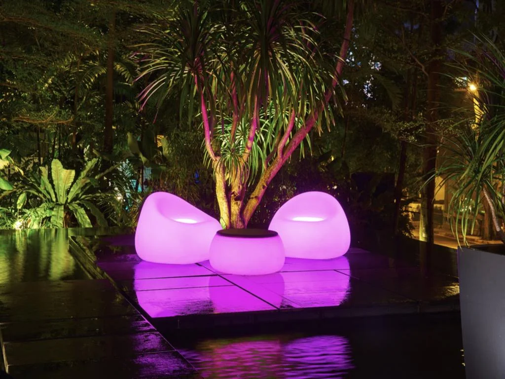 Glowing seatings outside the hotel building, only being lit up at night.