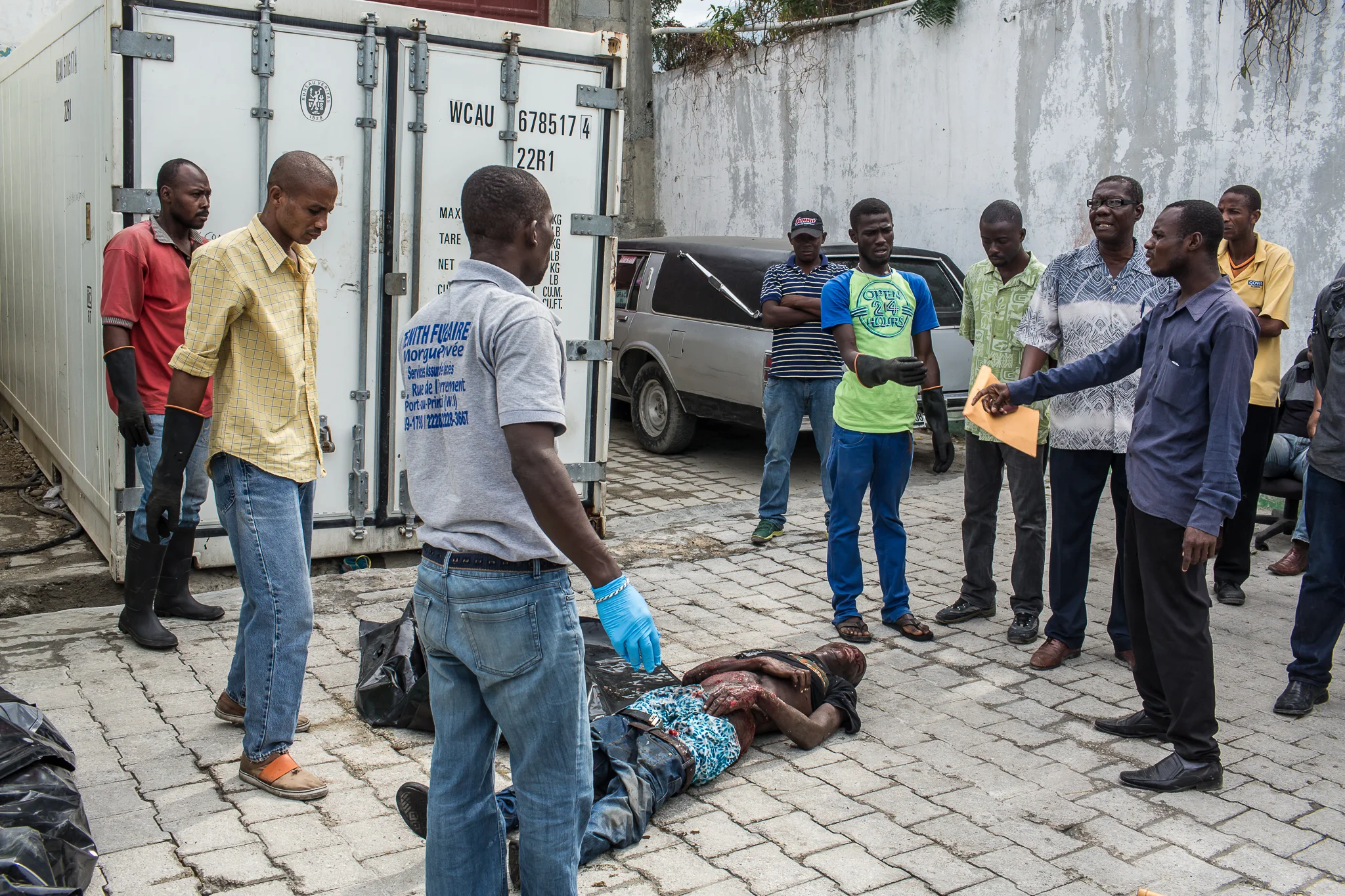 Morgue workers retrieve the body of Jolin Nicolas, 19, who was killed by police while participating an anti-government protest on Wednesday, December 17, 2014 in Port-au-Prince, Haiti.