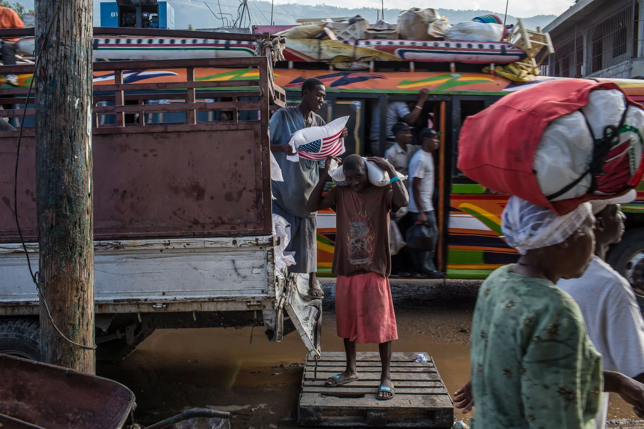 Men unload bags of rice from a truck on Friday, December 19, 2014 in Port-au-Prince, Haiti. While Haiti was once self-sufficient in rice production, cheap imported rice, particularly from America, has put many Haitian rice farmers out of business.