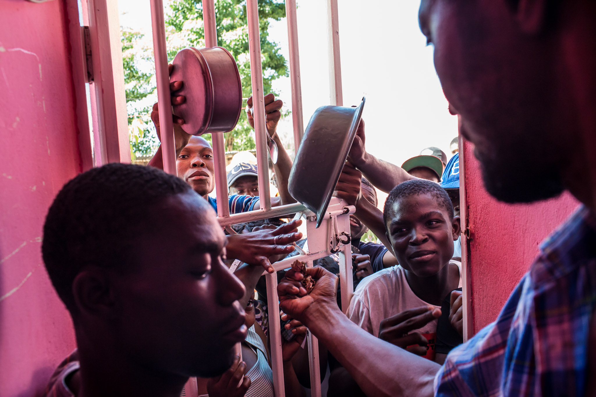  Owner Benoit Jean Wilfrid, right, collects money as people clamour for a plate of food at a restaurant in the Tapis Rouge neighborhood on Monday, December 22, 2014 in Port-au-Prince, Haiti. The restaurant was initially funded as a government program